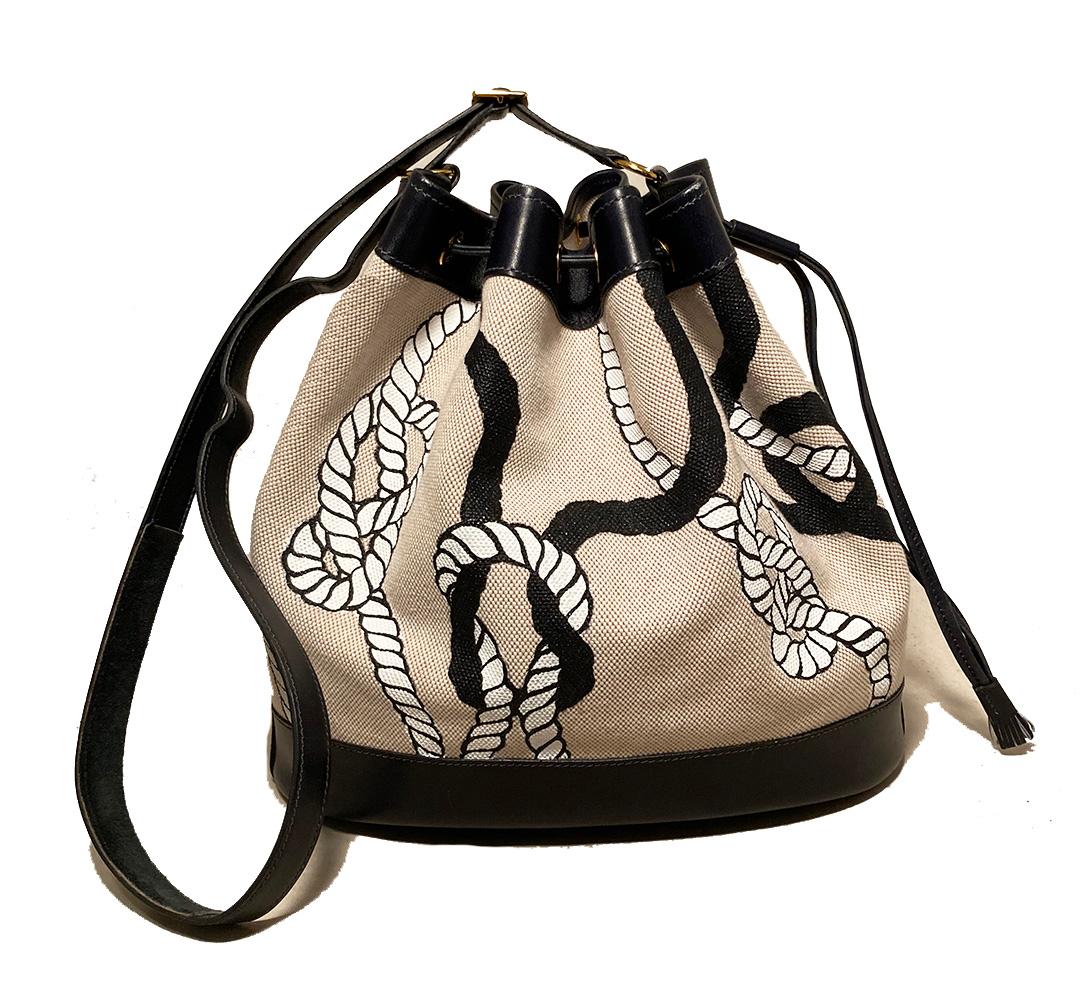 Hermes Vintage Bucket Bag Hand Painted in very good condition. Woven beige canvas exterior with hand painted black and white rope pattern trimmed with navy blue box leather and golden hardware. Buckle shoulder strap can be worn short or long. Top