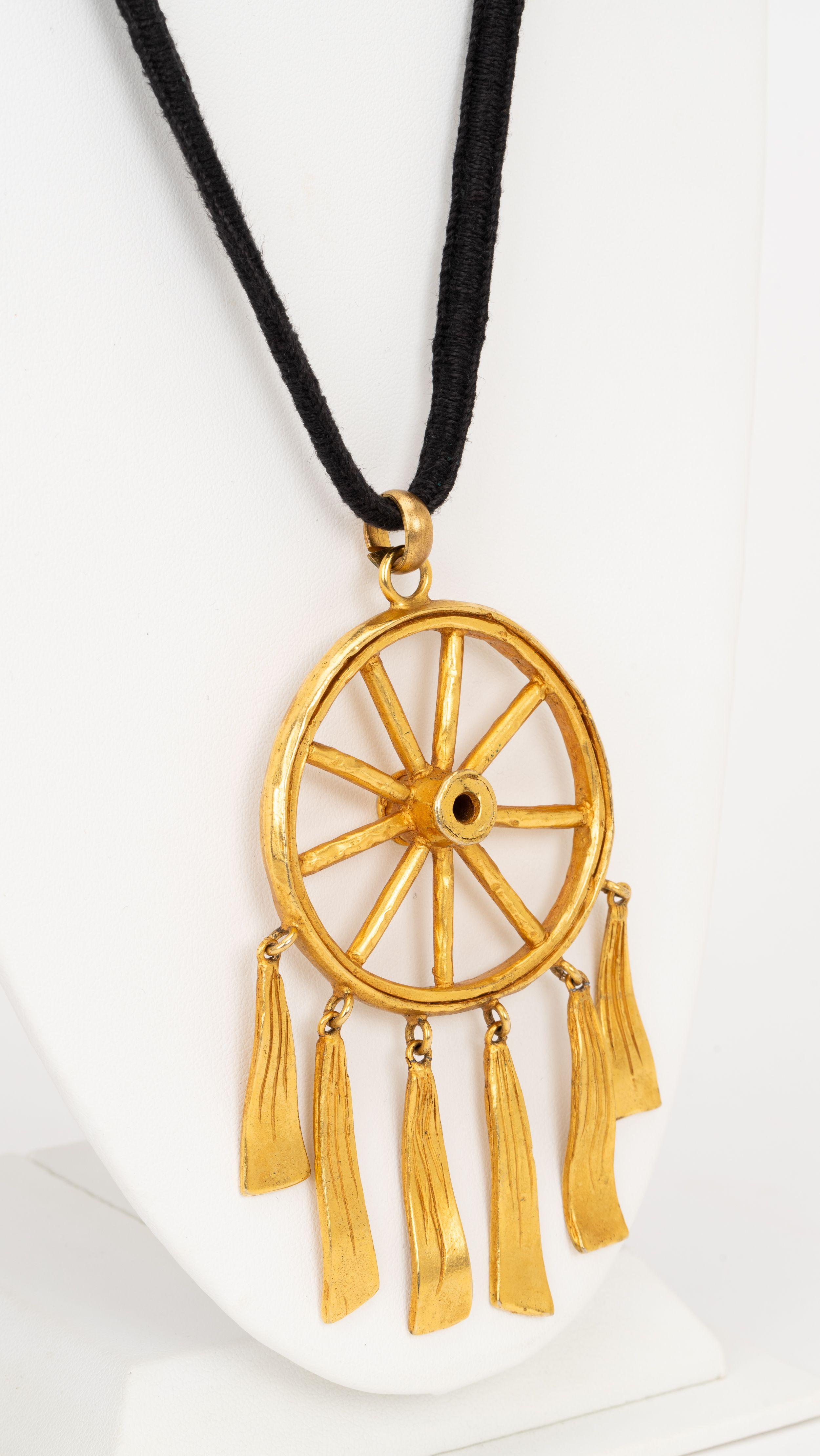 Highly collectible Hermès 80s vintage pendant necklace. Gold plated dream catcher pendant and thick black cord necklace. Pendant D 2.25”. Comes with original box.