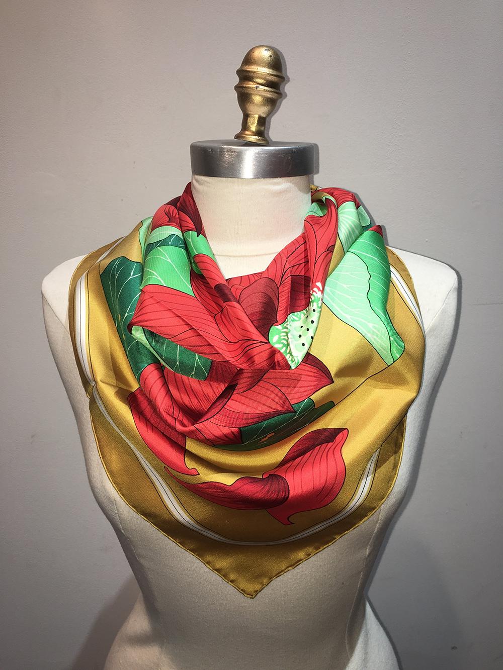 Hermes Vintage Fleurs de Lotus Silk Scarf in Gold c1970s in excellent condition. Original silk screen design c1976 by Christiane Vauzelles features a beautiful assortment of red lotus flowers with green leaves in a circle pattern over a marigold