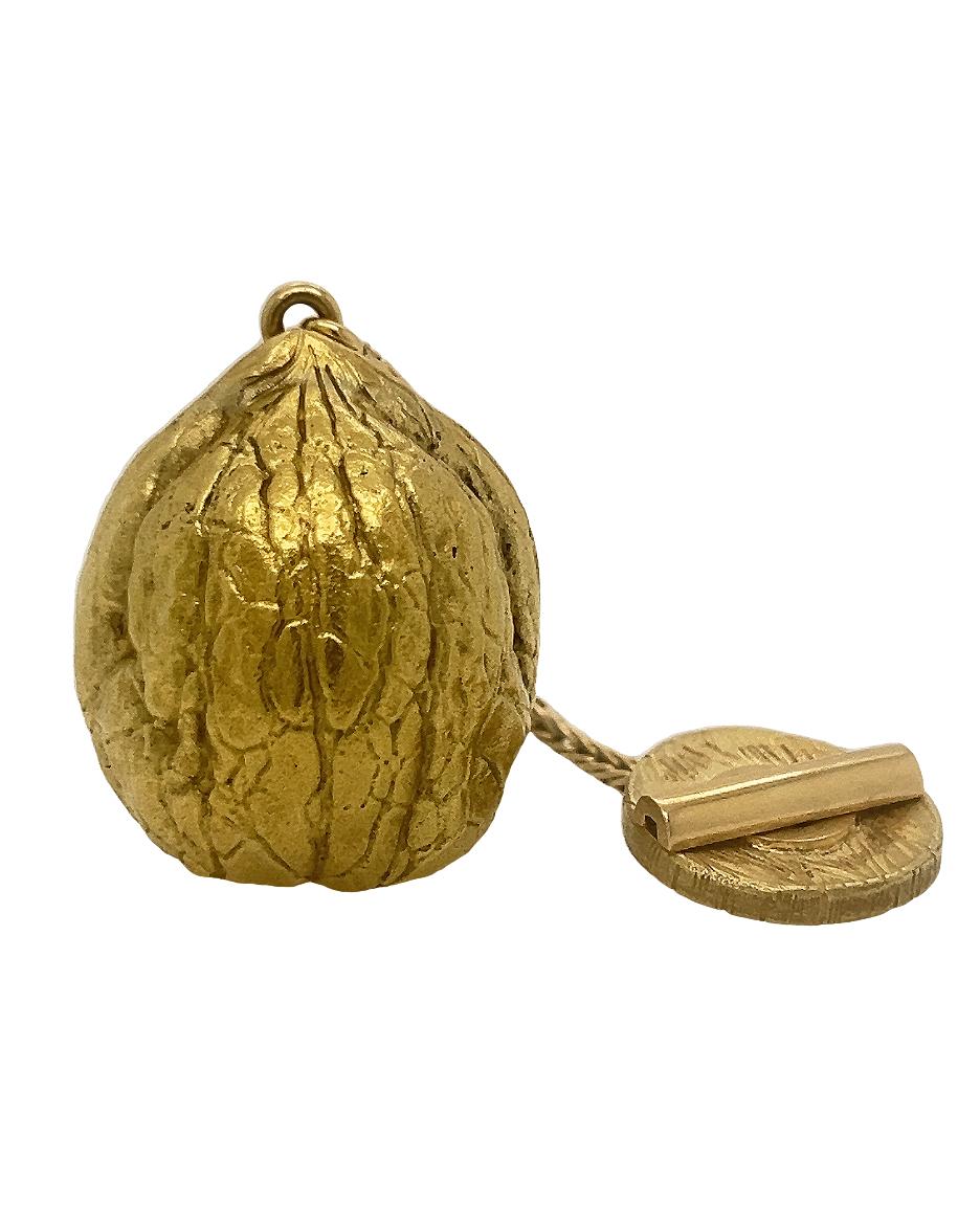 Walnussförmiger Anhänger aus 18 Karat Gold, signiert von Hermes. 

Mechanische Uhr in funktionierendem Zustand. 

Versteckte Uhr im Inneren des Anhängers. 