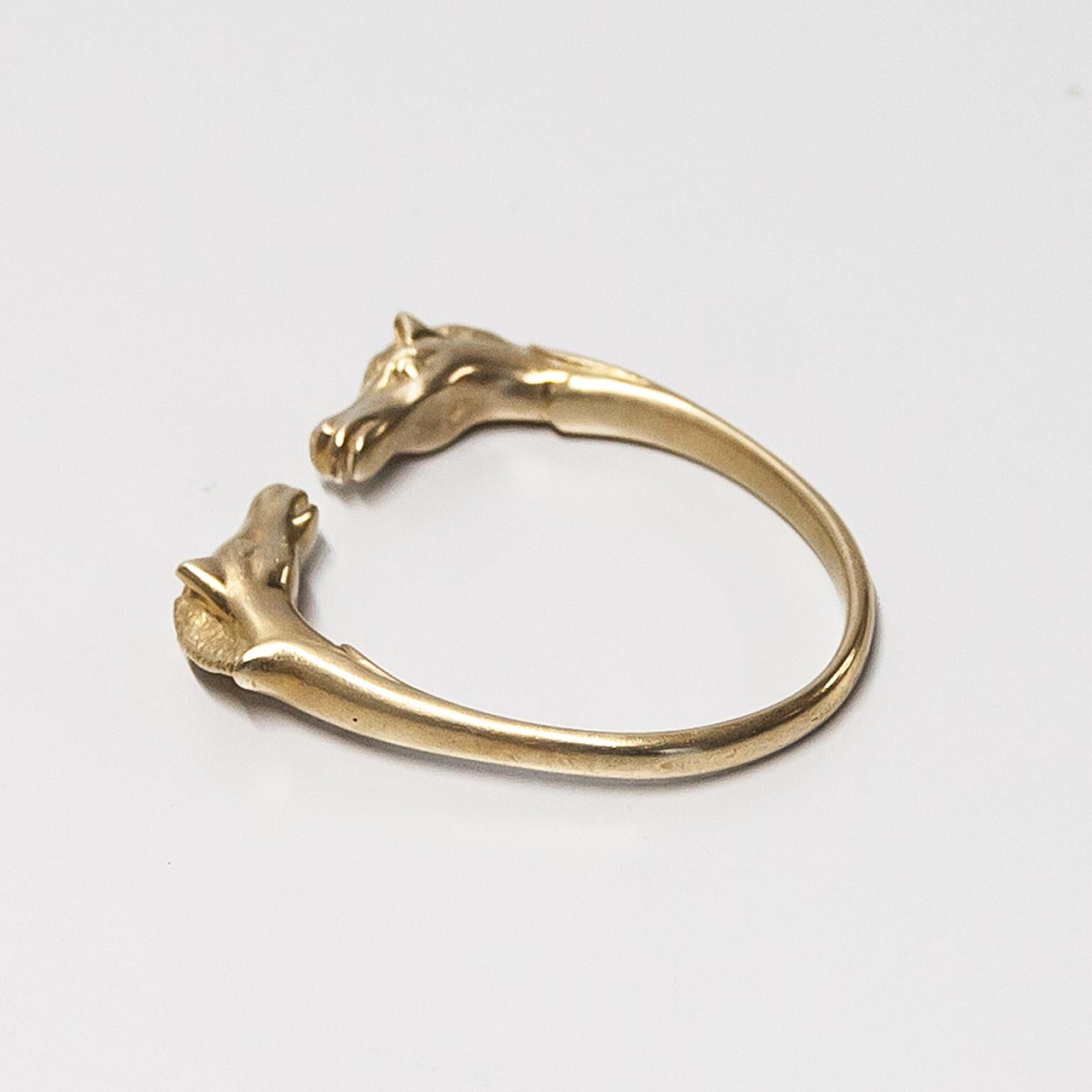 Sehr seltenes Hermès Galop-Armband aus goldenem Messing mit doppelten Pferdeköpfen, seitlich signiert mit Hermès Paris. Einstellbare Breite für die meisten Handgelenkgrößen, kann breiter gezogen oder für dünnere Handgelenke zusammengeschoben werden.