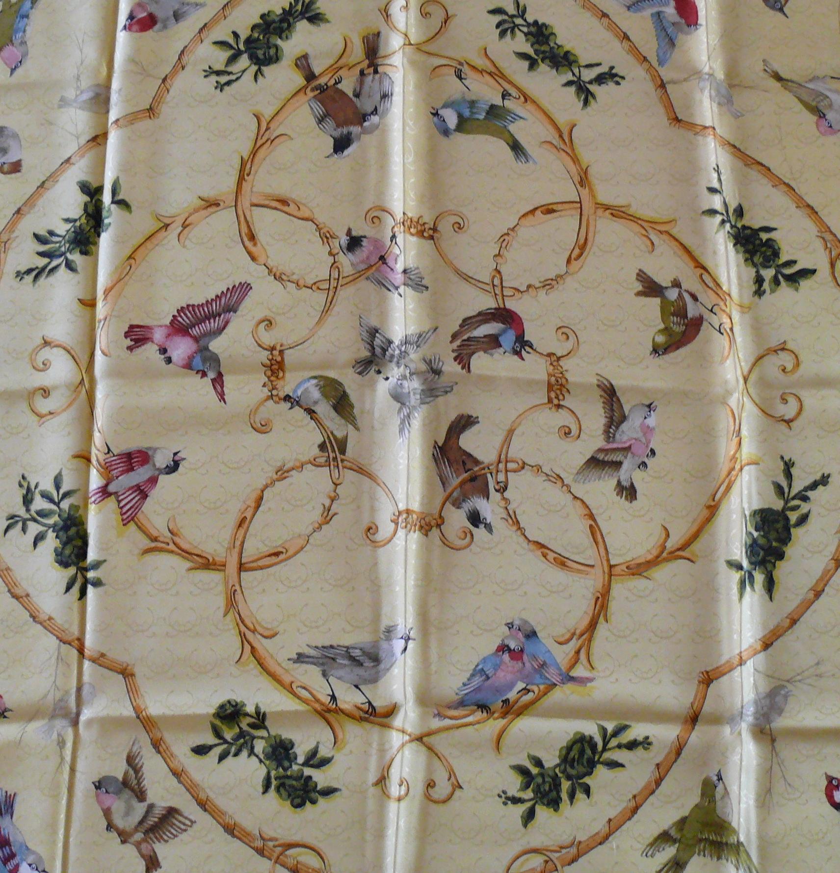 HERMES vintage jacquard silk carré scarf LA CLE DES CHAMPS, designed by FRANCOISE FACONNET, featuring birds adorned with gold Baroque ornaments on a yellow background.

First 1965 edition.

Marked HERMES PARIS
Signed FR. FACONNET.

Missing