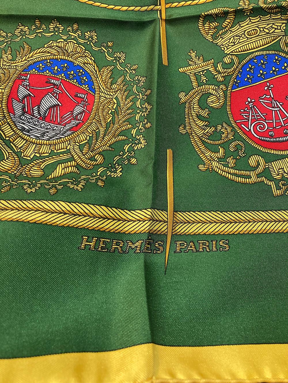Hermes Vintage Les Armes de Paris Silk Scarf c1950s in excellent condition. Original silk screen design c1954 by Hugo Grygkar features the various coat of arms of France in blue red and grey surrounded by gold ornate filagree borders over a green