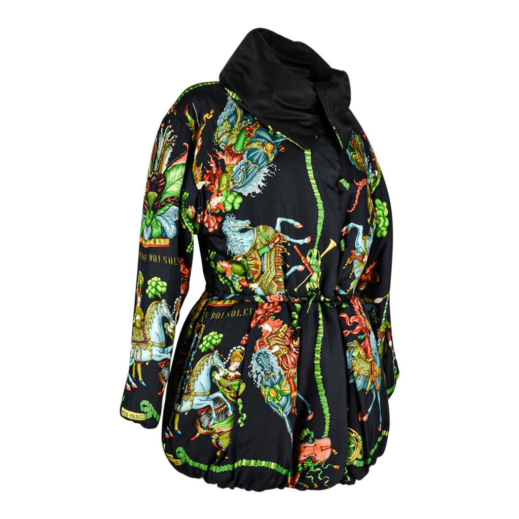 Guaranteed authentic Hermes dramatic reversible silk Les Fetes Du Roi Soleil wadded jacket.      
Striking balloon hem with drawstring waist and box pleat detail.
Black with brilliant jewel tones and fresh greens of men and horses in full