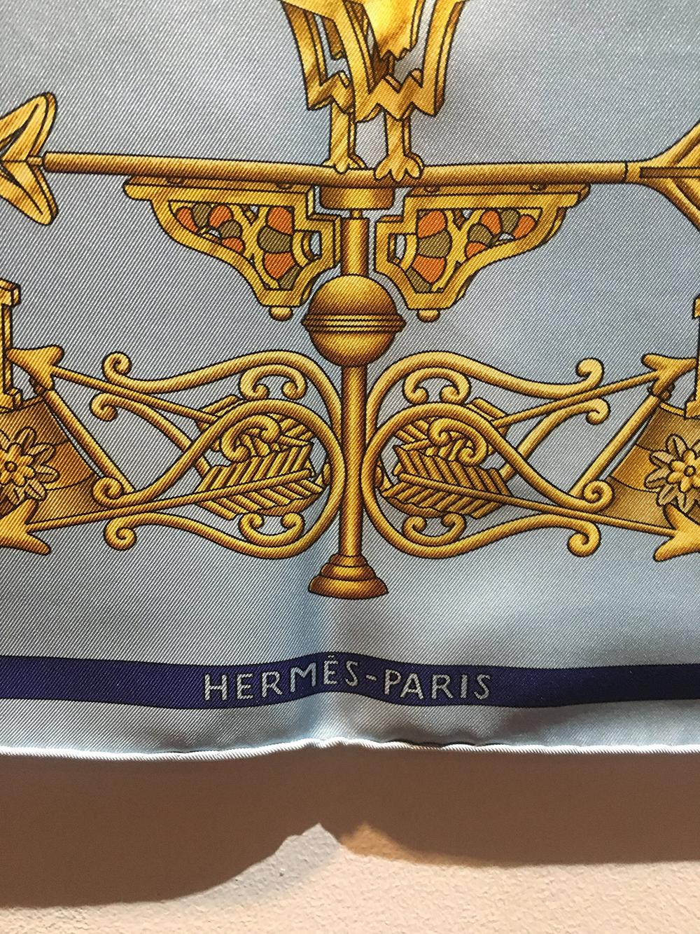 Hermes Vintage Light Blue Les Girouettes Silk Scarf c1999 in excellent condition. Original silk screen design c1999 by Joachim Metz features a light blue background with an array of golden weathervane towers throughout surrounded by a blue/gold and