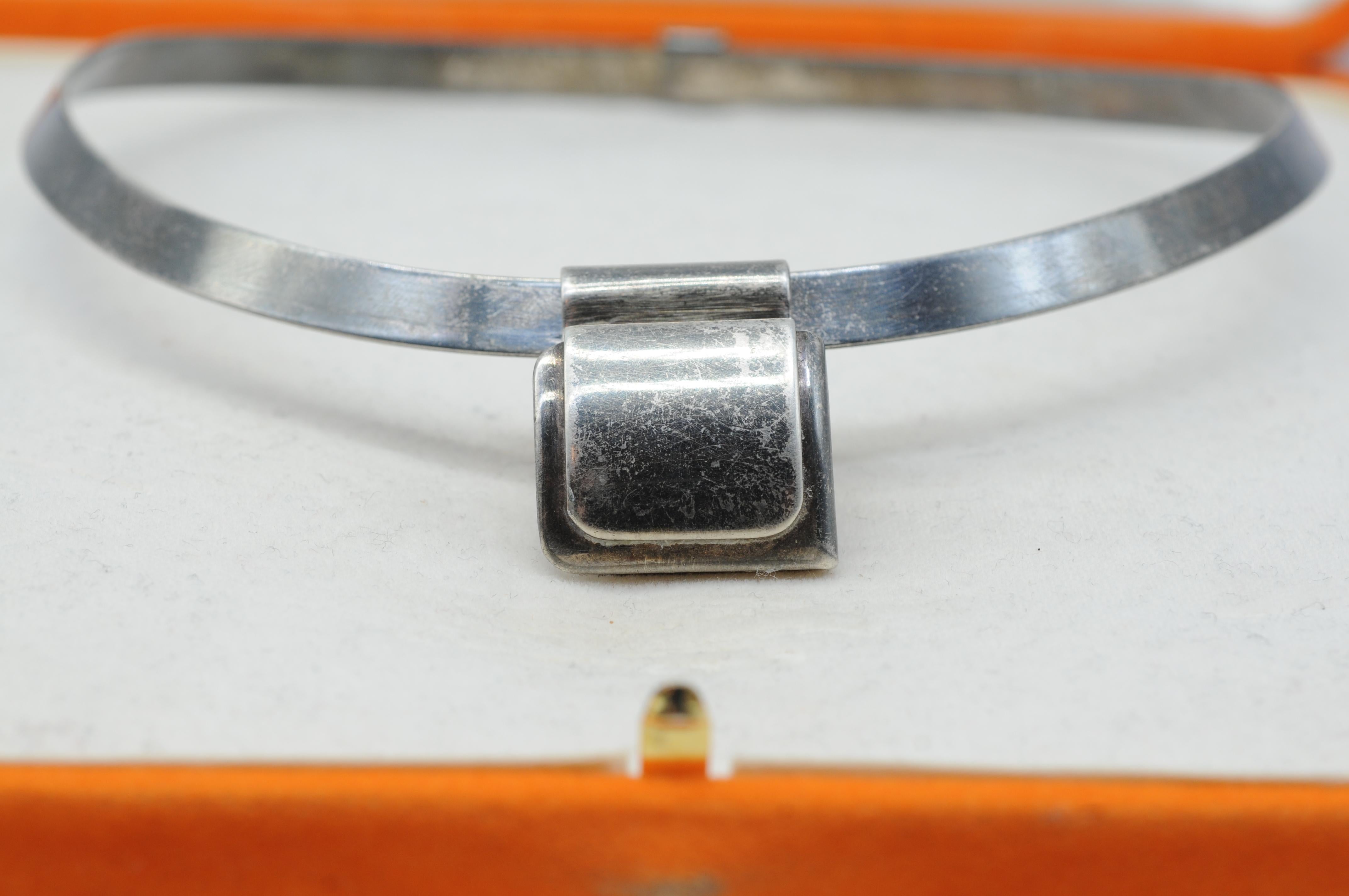 Ti presentiamo l'incantevole collana vintage antica dell'illustre marchio Hermes, realizzata in argento sterling. Questo splendido gioiello non è una semplice collana, ma un tesoro venerato e senza tempo, che porta il marchio della prestigiosa
