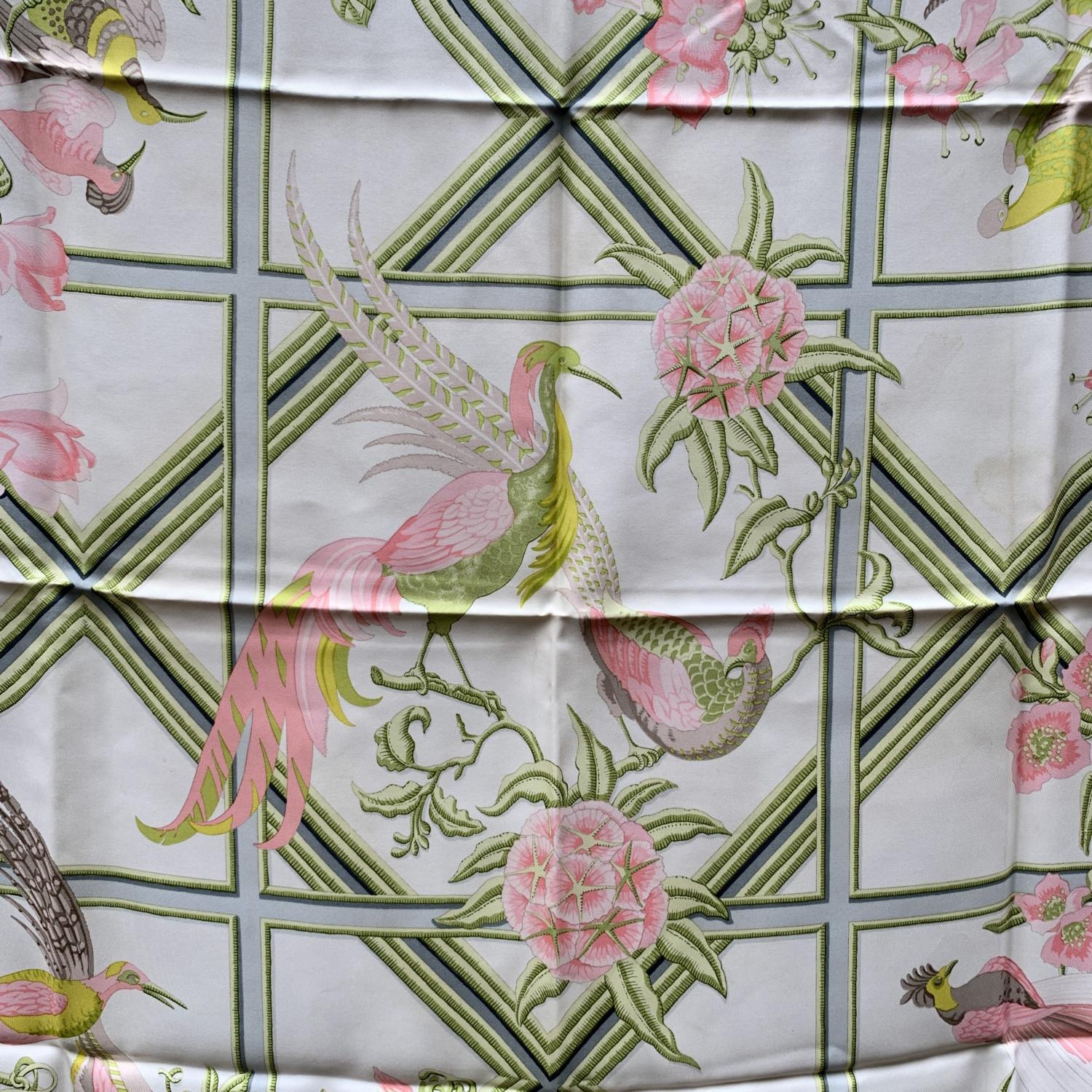 Vintage Hermes silk scarf titled 'Caraibes' designed by Christiane Vauzelles, and first issed in 1974 . It has various birds and flower in baby pink colorway on white background. It is signed 'Hermes, Paris' with copyright symbol. It has the
