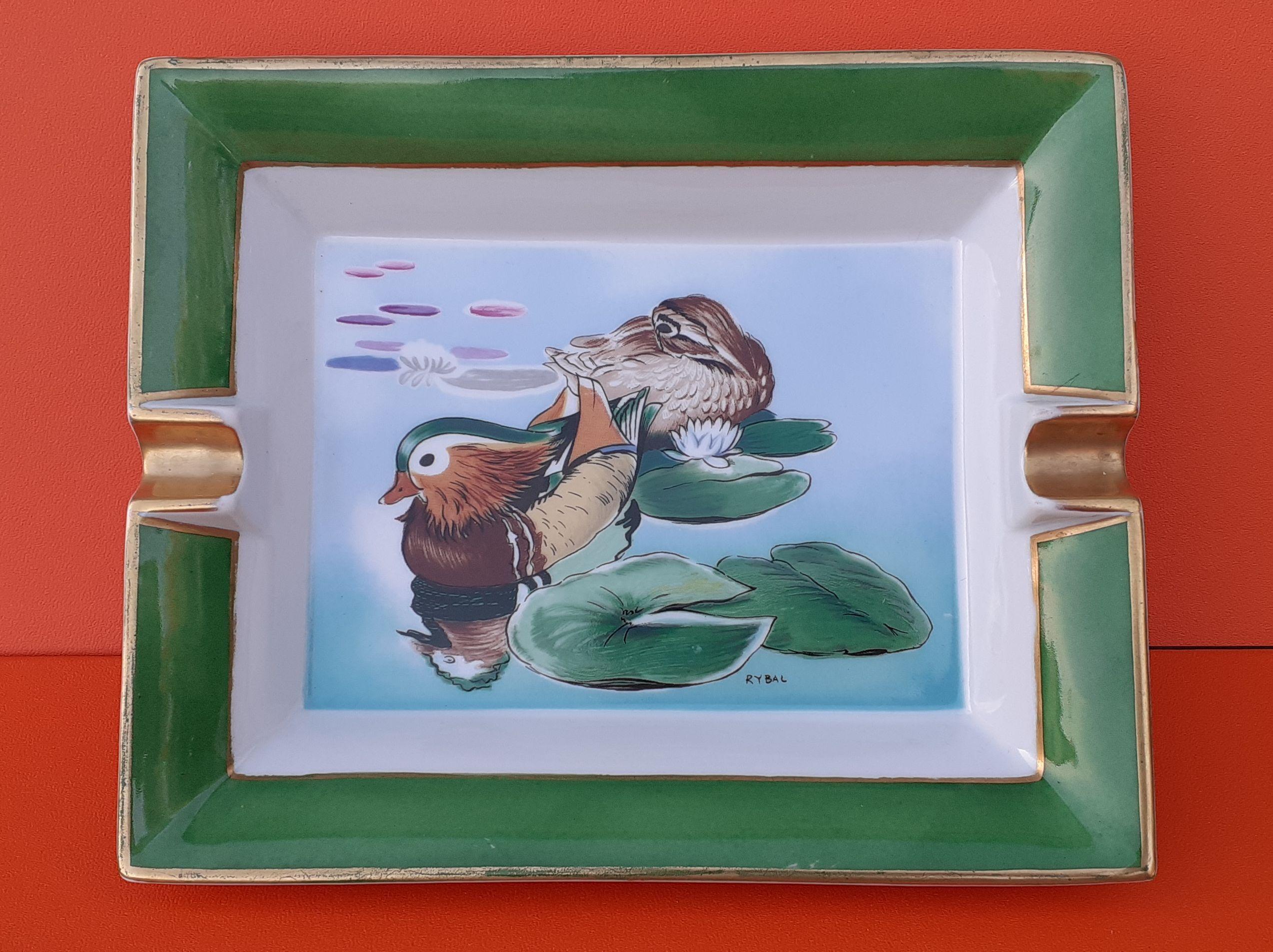 Niedlich Authentic Hermès Aschenbecher

Muster: 2 Enten in einem Teich:: Seerosen

Auf den Fotos ist kaum zu erkennen:: dass das Muster lackiert ist:: die Farben sind wunderschön und glänzend!

Made in France

Hergestellt aus Porzellan mit goldenen