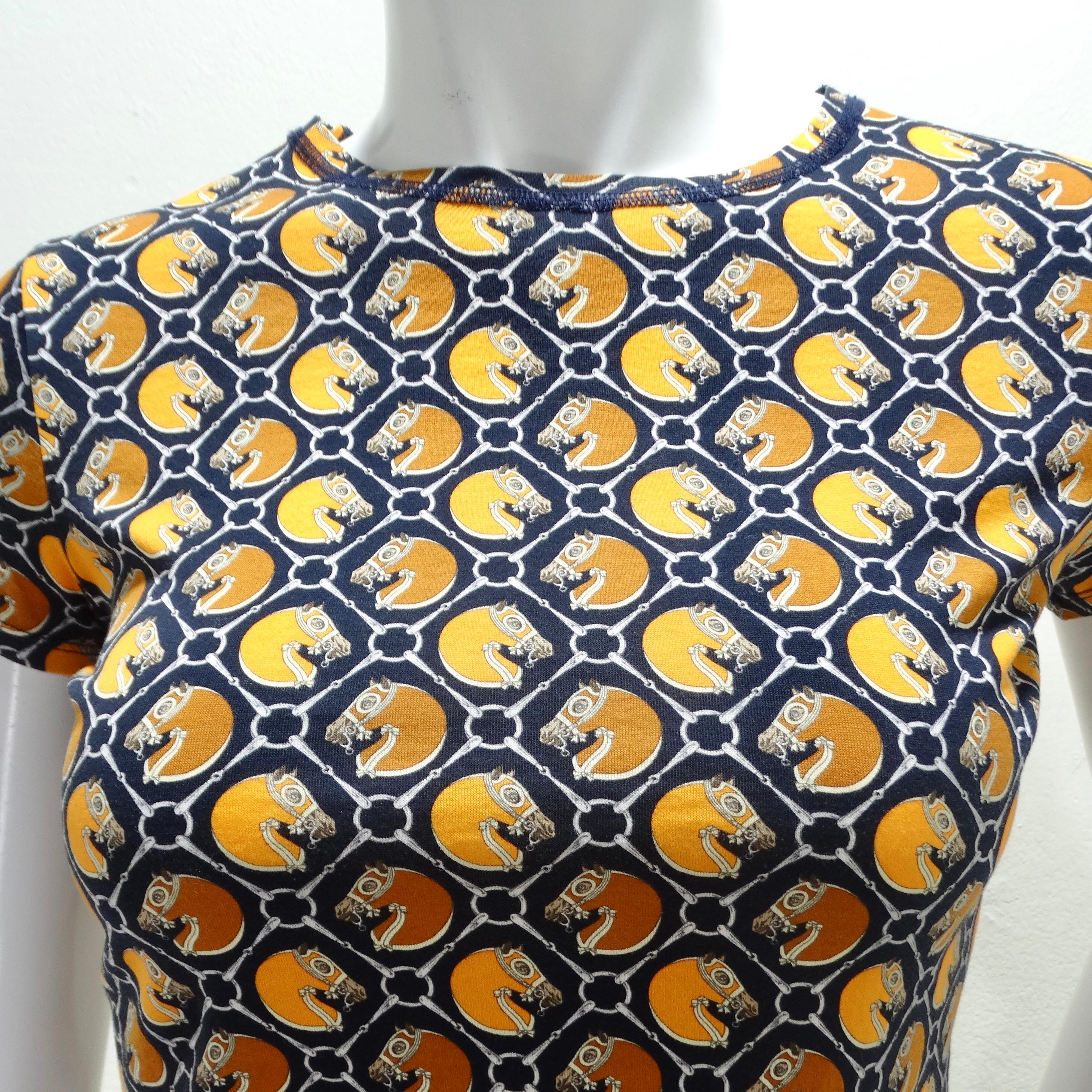 Voici le T-shirt en coton imprimé Hermes Vintage, un classique de la garde-robe qui allie harmonieusement confort et élégance intemporelle. Ce t-shirt en coton, orné d'un imprimé de chevaux blanc, orange et bleu marine sur toute sa surface, dégage
