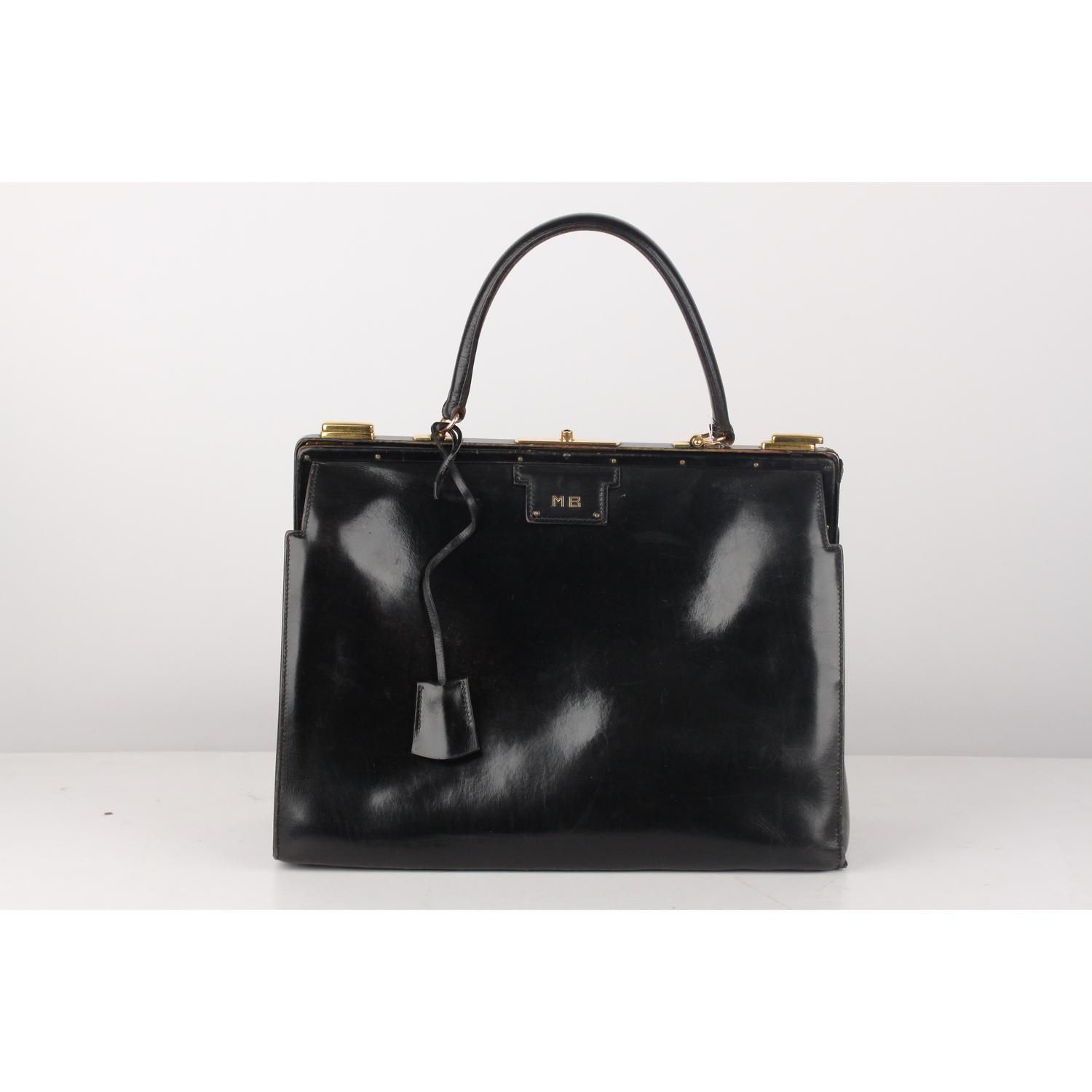 Rare vintage Hermes 'Sac 404' crafted in black leather with gold metal hardware. Front MB letters on the front (they are probably the initials of the old owner).  Structured bag with with top push closure and side lock clasps. Key with leather