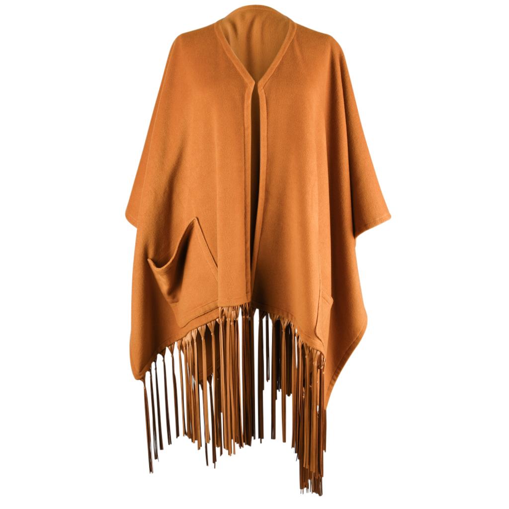 Mightychic bietet einen einzigartigen Hermes Vintage-Schal / Poncho mit einem dramatischen Lederfransen.  
Auffallend warmer, goldfarbener Schal aus Kaschmir und Wolle im Poncho-Stil.
Reichhaltig mit langen, üppigen Lederfransen.
Das Leder ist