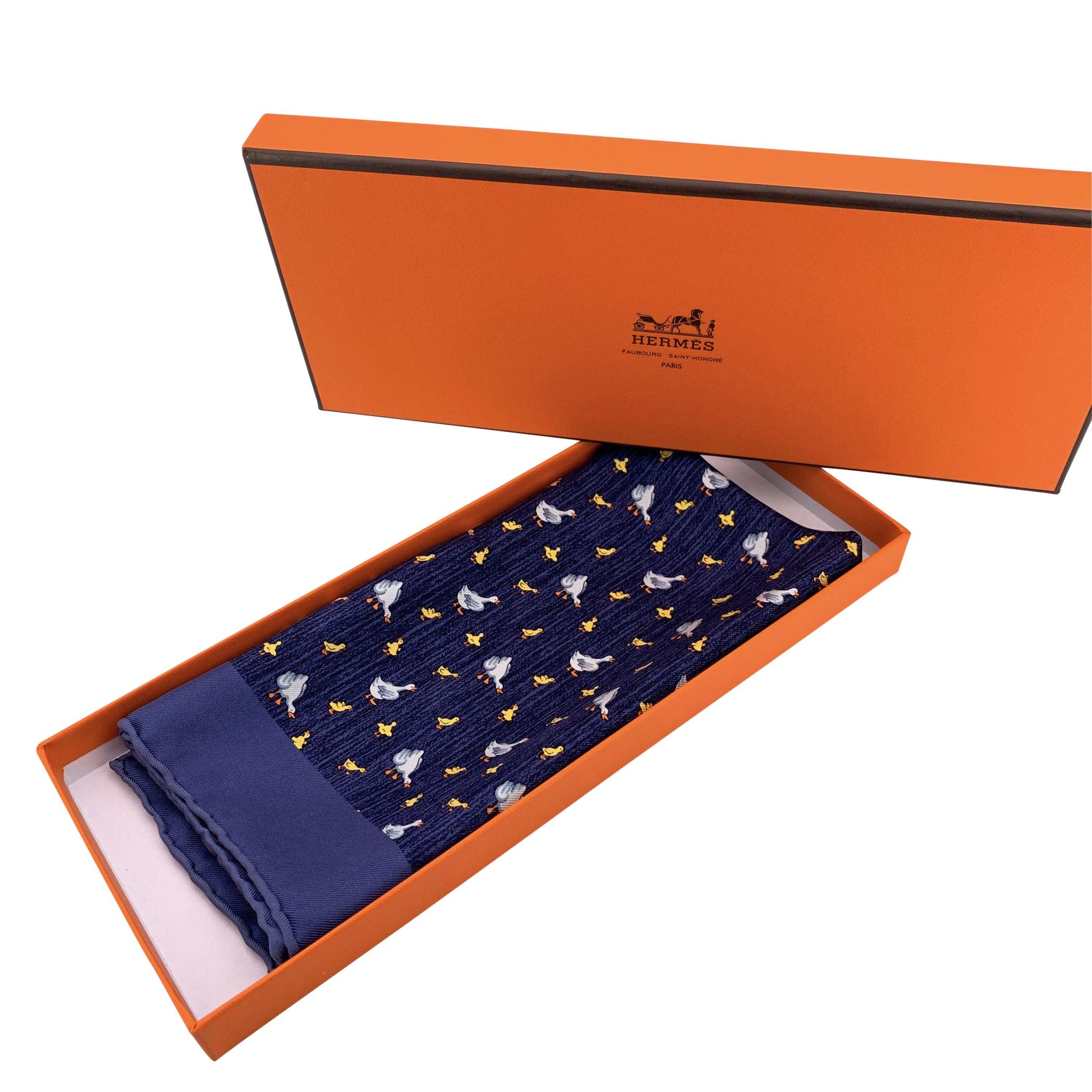 Graziosa pochette da taschino in seta di Hermès con un'adorabile stampa di anatre e anatroccoli su uno sfondo blu scuro. Realizzato in twill di seta 100% vintage, mette in mostra la rinomata maestria e l'attenzione ai dettagli della Maison, con