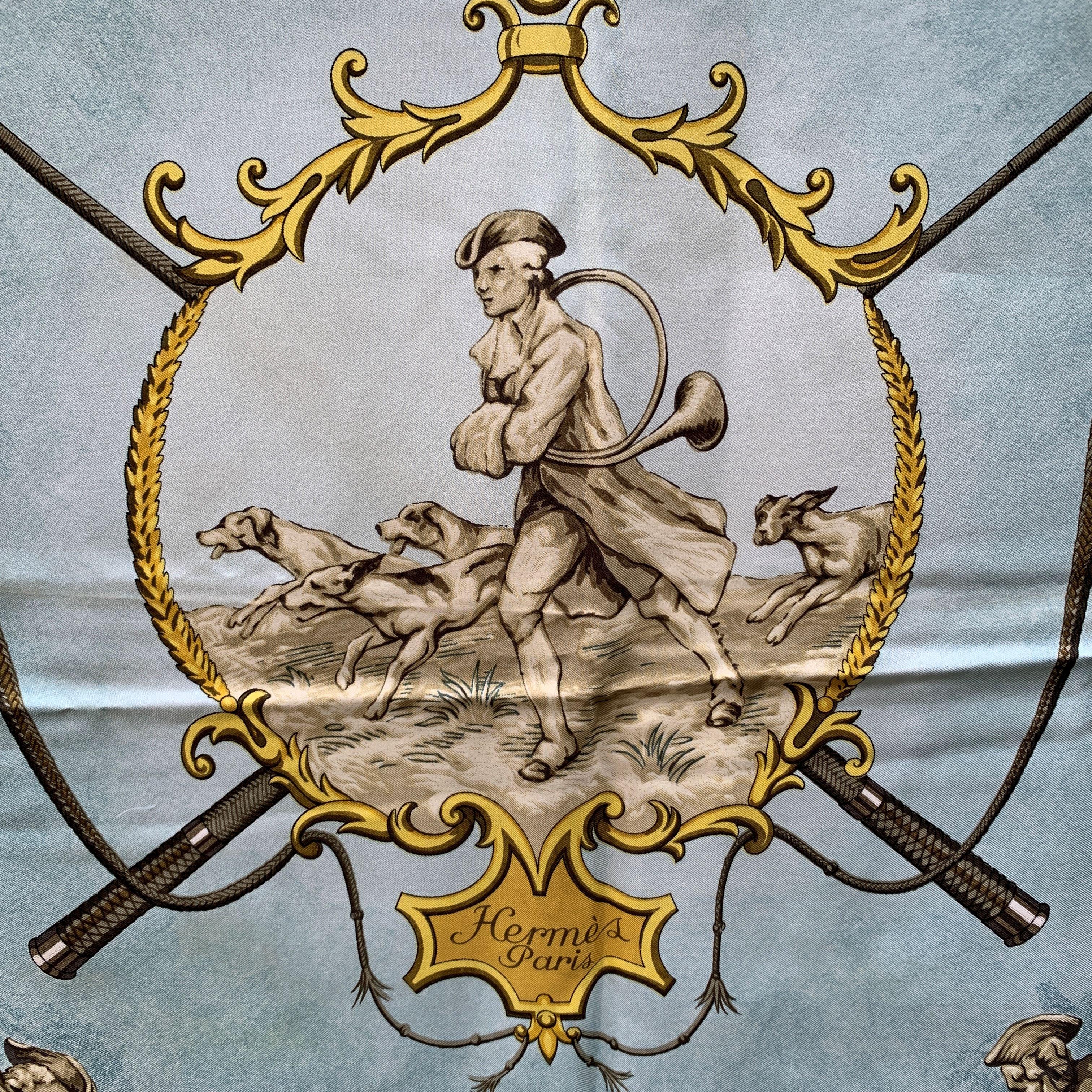 Vintage HERMES scarf ' Chiens et Valets ' by Charles Jean Hallo and originally issued in 1963. This design has never been re-issued. It depicts a hunting scene. Colors: Light blue 100% Silk. Hand rolled edges.It measures approx. 90cm by 90cm.