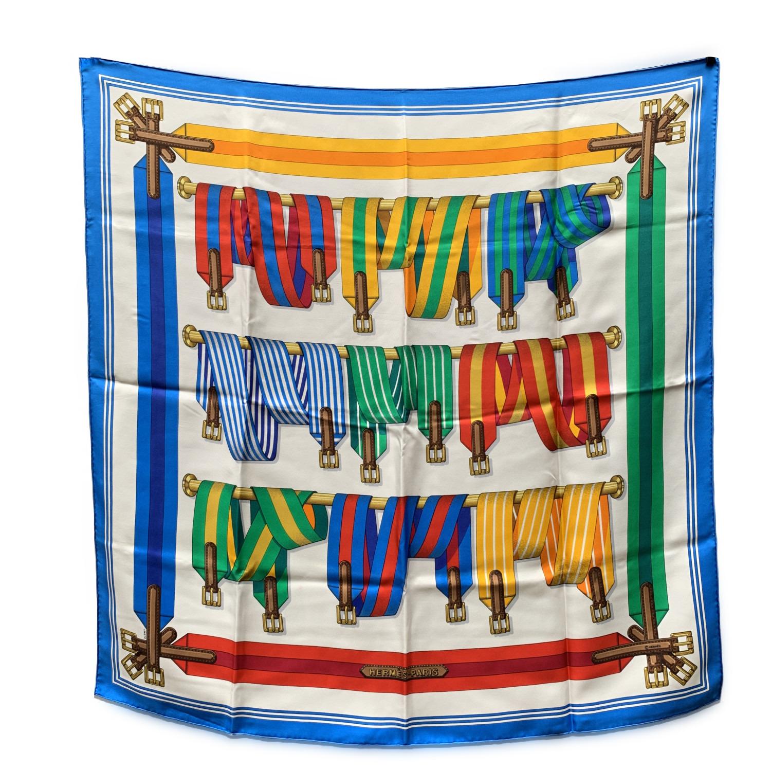Vintage HERMES scarf 'Les Sangles' (Belts) was designed by Joaquim Metz and first issued in 1985. Multicolor striped belt and buckle pattern with blue borders. The 'HERMES Paris' signature in the lower center border. 100% silk. Approx measurements: