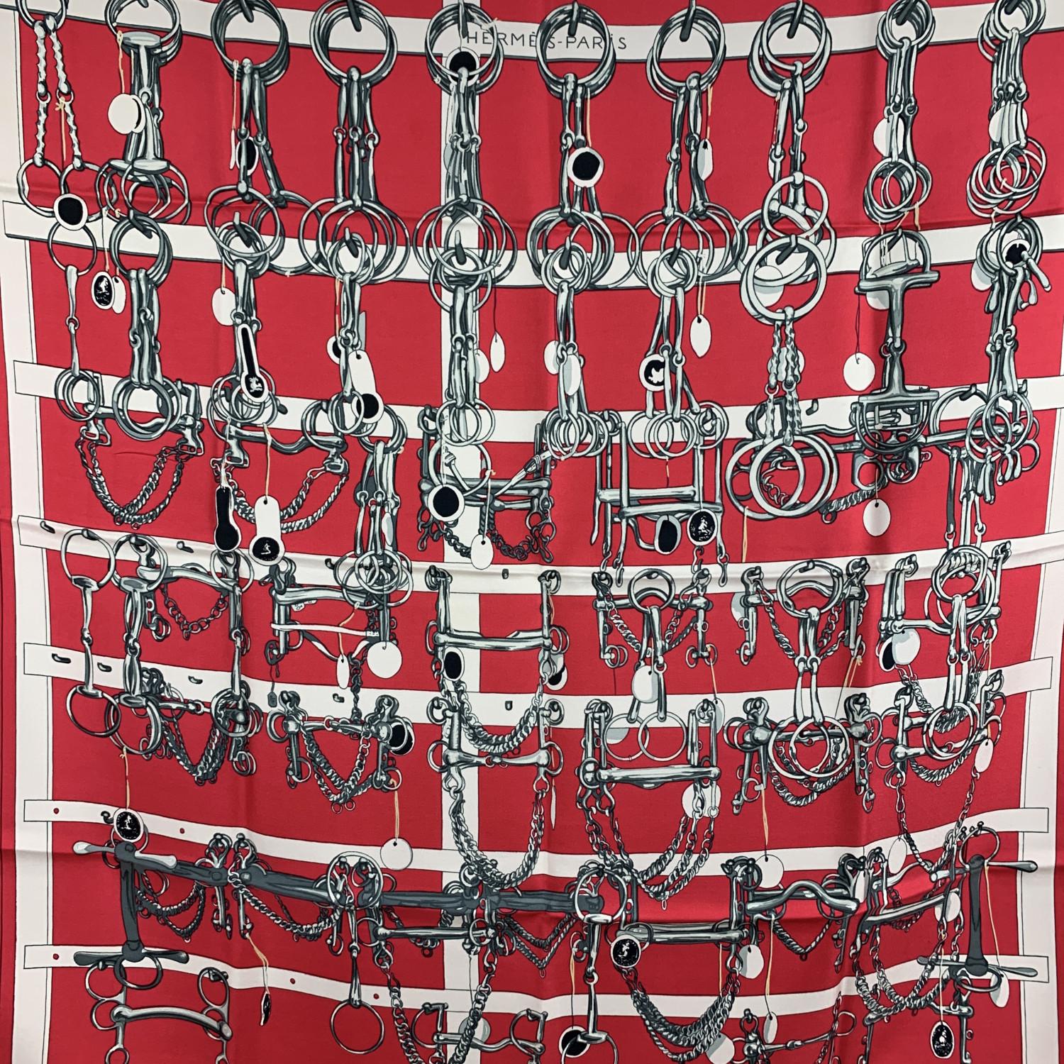 HERMES silk scarf named 'Mors et Filets', designed by Francoise Heron and issued the first time in 1966. Equestrian theme. Hand rolled edges. Main colors are red, white and grey. Measurements: Approx 35 x 35 inches. 'HERMES PARIS' printed in the