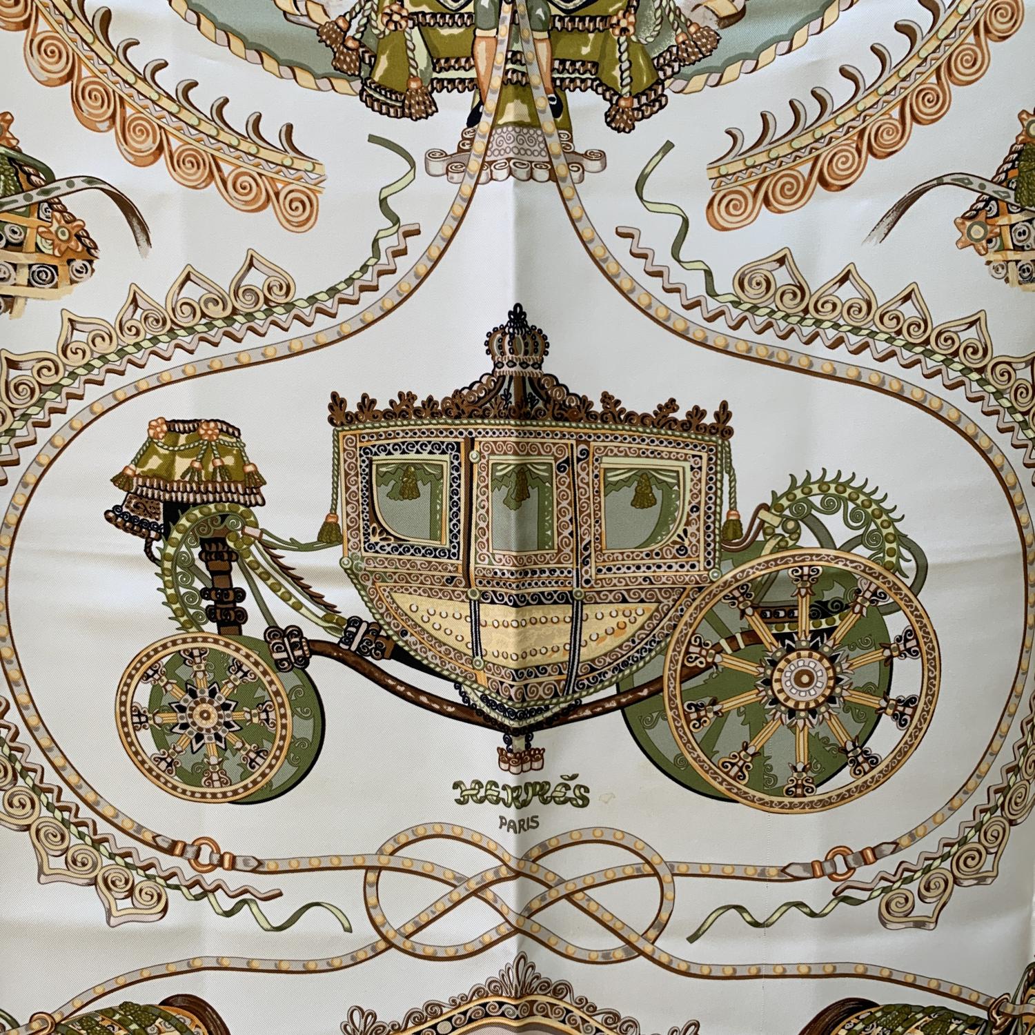 HERMES ' Paperoles' silk scarf. Designed by Claudia Stuhlhofer-Mayr and first issued in 2000. Miltary green borders. It depicts a ceremonial carriage surrounded by horses. Hand rolled edges. Made in France. Composition: 100% silk. Composition tag is