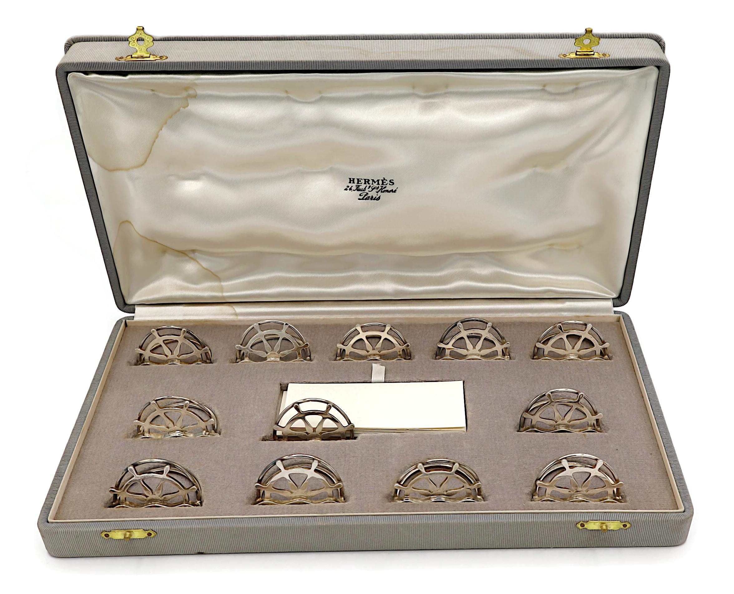 Set vintage HERMES di 12 segnaposto o portamenù nautici in argento con ruota di nave.

Un set raro e raffinato per gli appassionati di vela o per i proprietari di yacht.

HERMES in rilievo.
Punzone francese 