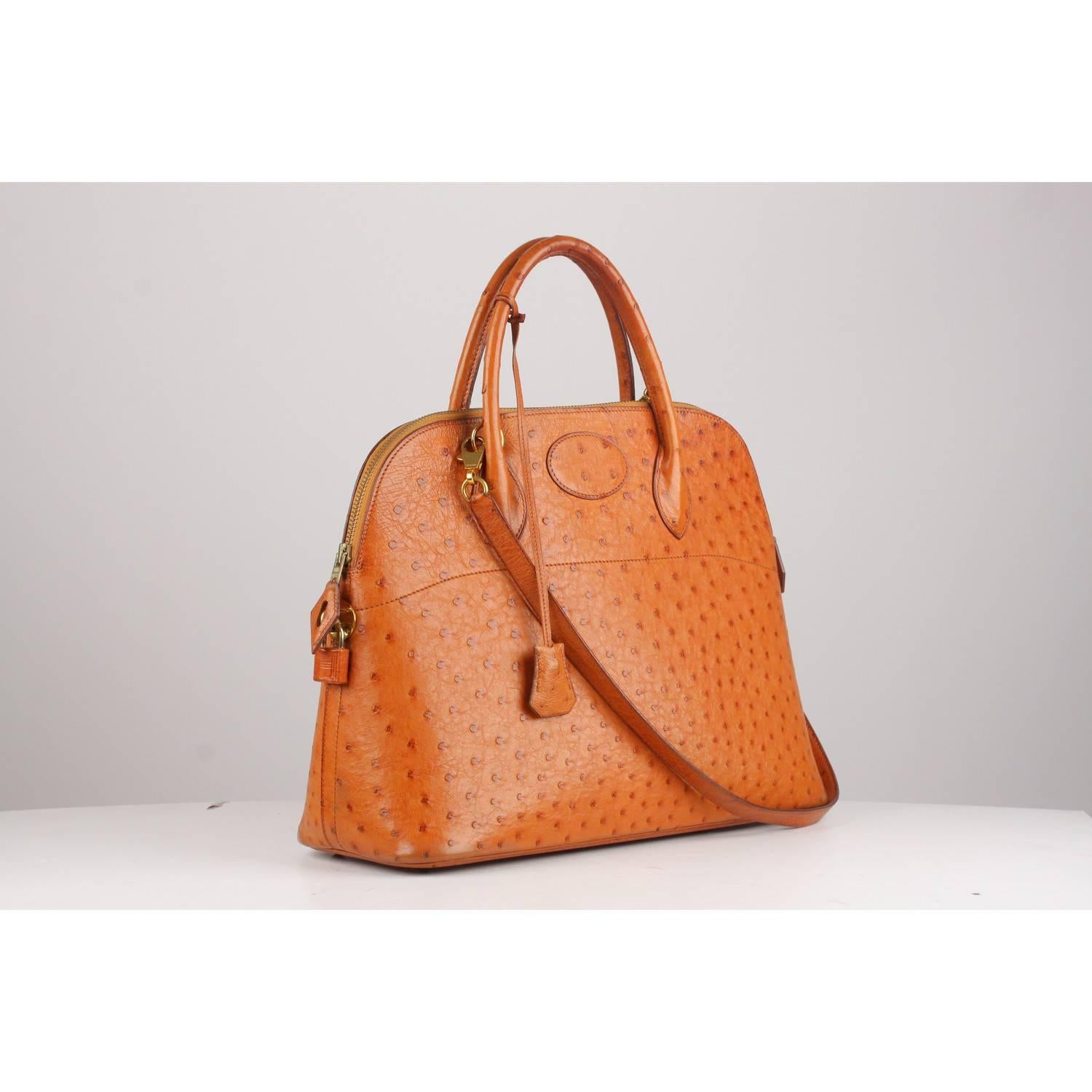 Sophisticated and timeless Hermes Bolide Bag crafted in tan ostrich skin leather from 1992 (blind stamp is 'V' encased in a  circle). 
It features a doomed top with double top rolled leather handles and removable shoulder strap.  doomed top with