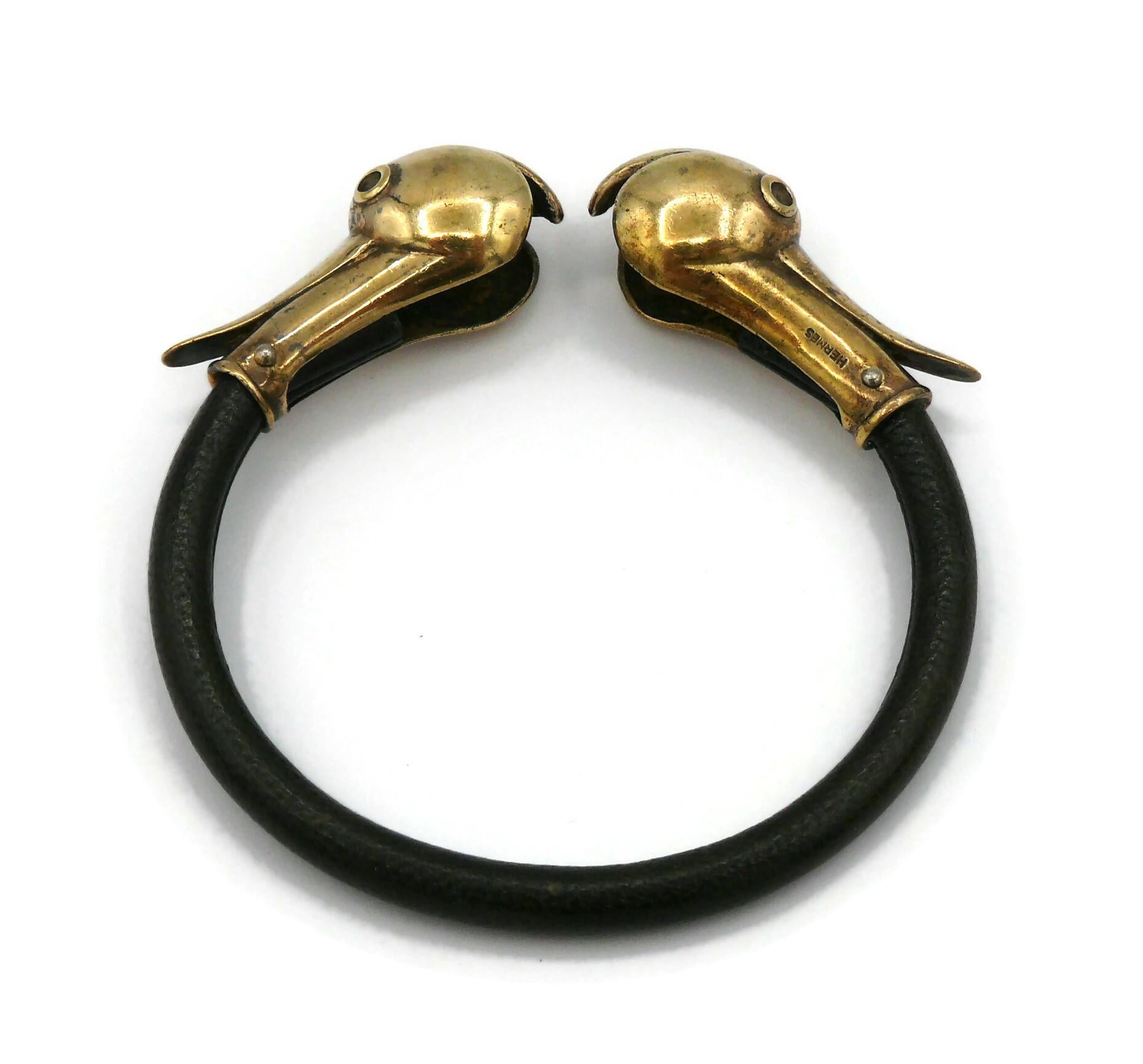 HERMES vintage uber rare dark brown leather bangle bracelet featuring two duck heads made of vermeil.

Slips on (no closure system).

Embossed HERMES (on each duck head).
French silver crab hallmark.
Silversmith's hallmark.

Indicative measurements