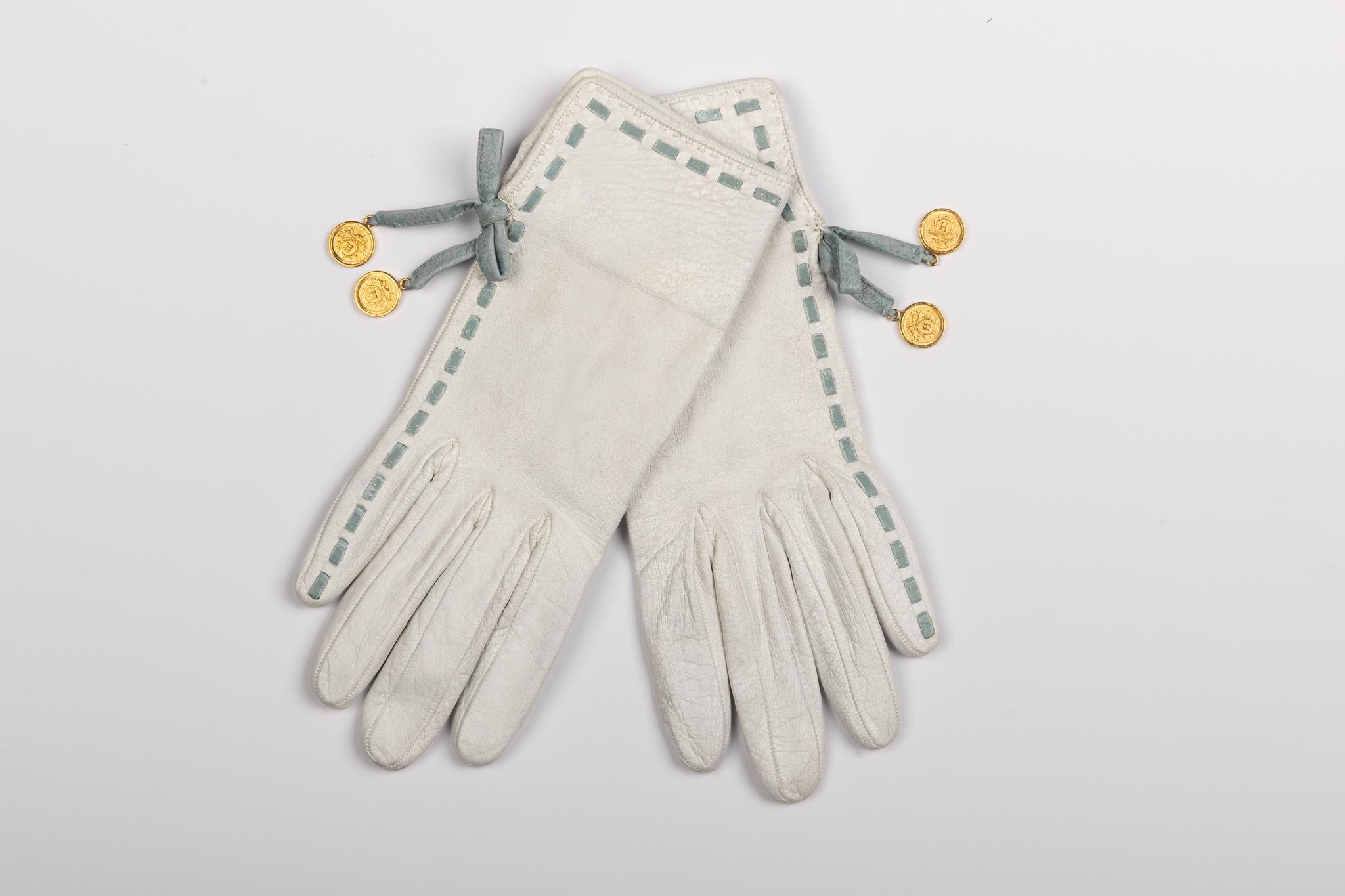 Hermes vintage 2 tone ladies gloves. White leather with celeste details and gold coins. Size 6. Come with original box.
