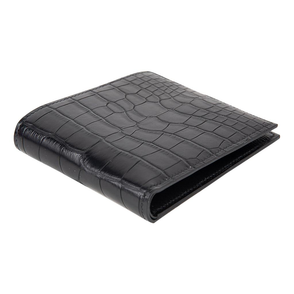 Guaranteed authentic Hermes Men's Black MC2 Copernic compact bi-fold wallet features matte Alligator.
Interior is chevre with eight credit card slots, two flat pockets and one paper money slot.
Sleek clean lines.
HERMES Paris Made in France on