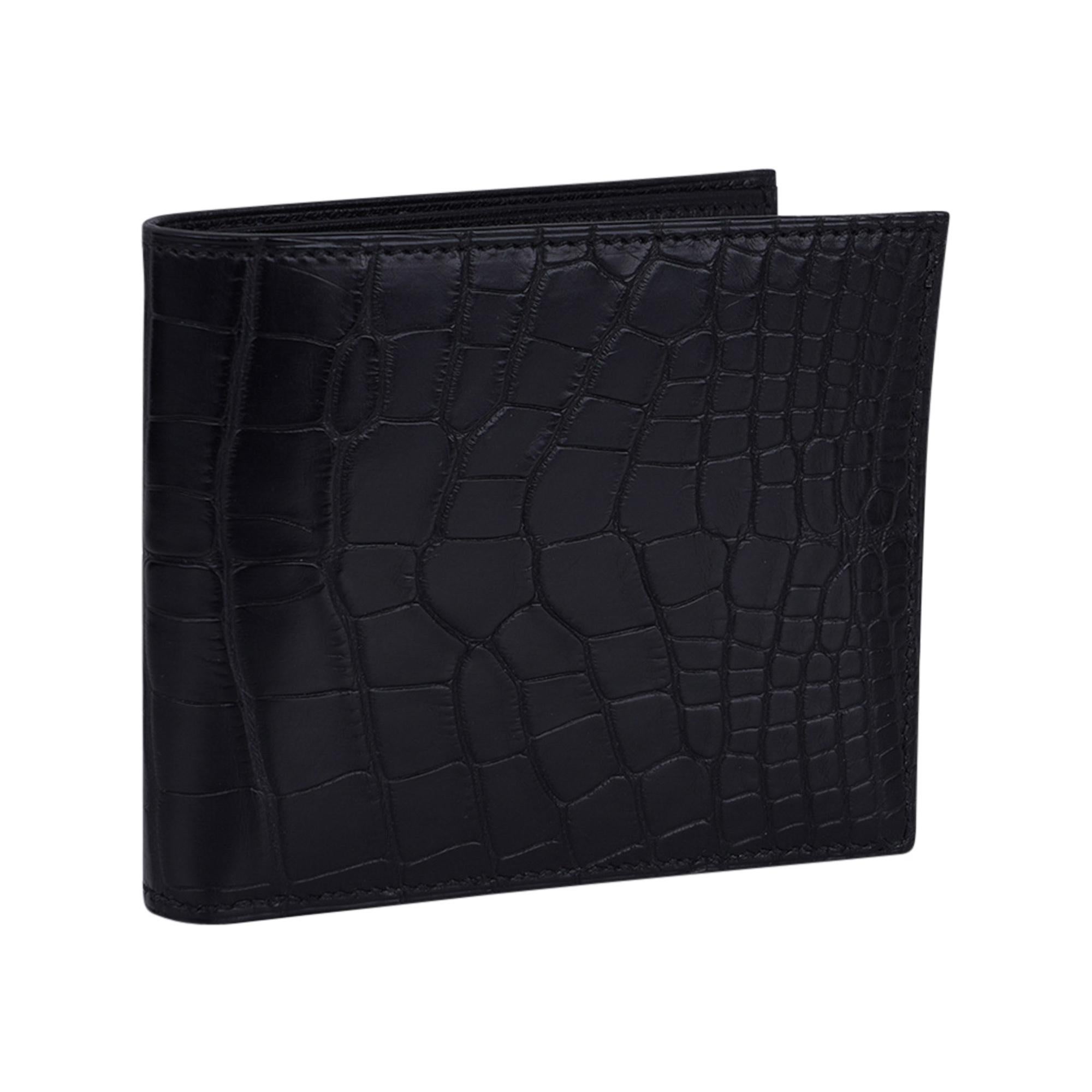 Mightychic offers an Hermes Men's Black MC2 Copernic compact bi-fold wallet featured in Black  matte Alligator.
Interior is chevre with eight credit card slots, two flat pockets and one paper money slot.
Sleek clean lines.
HERMES Paris Made in