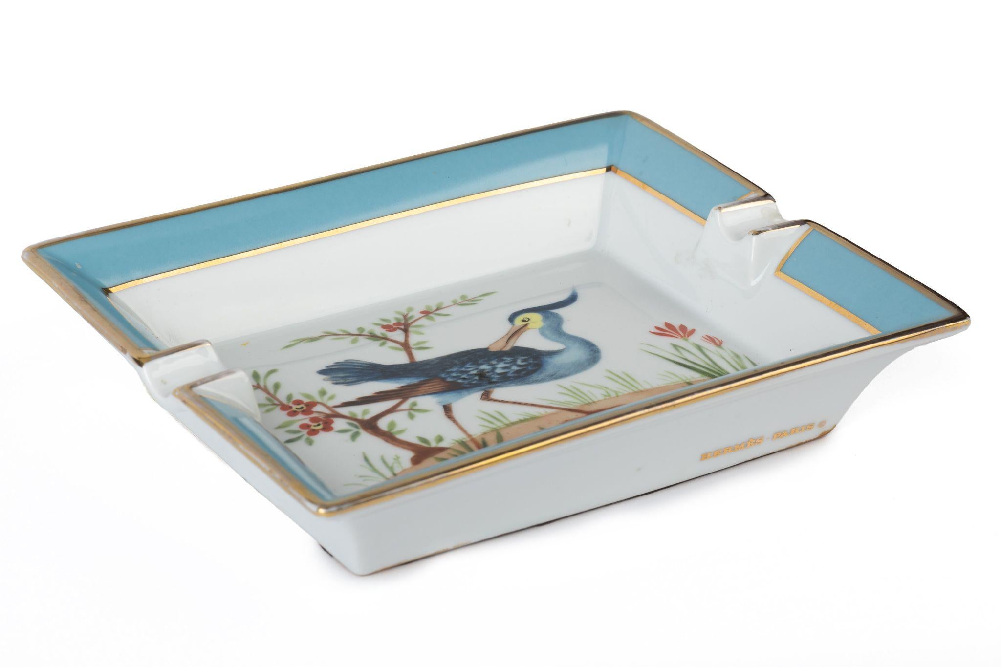 Hermès signature ashtray in light blue with a bird design in blue and yellow. The edges are colored light blue. Suede stamped bottom. The piece is in excellent condition. Includes original box.