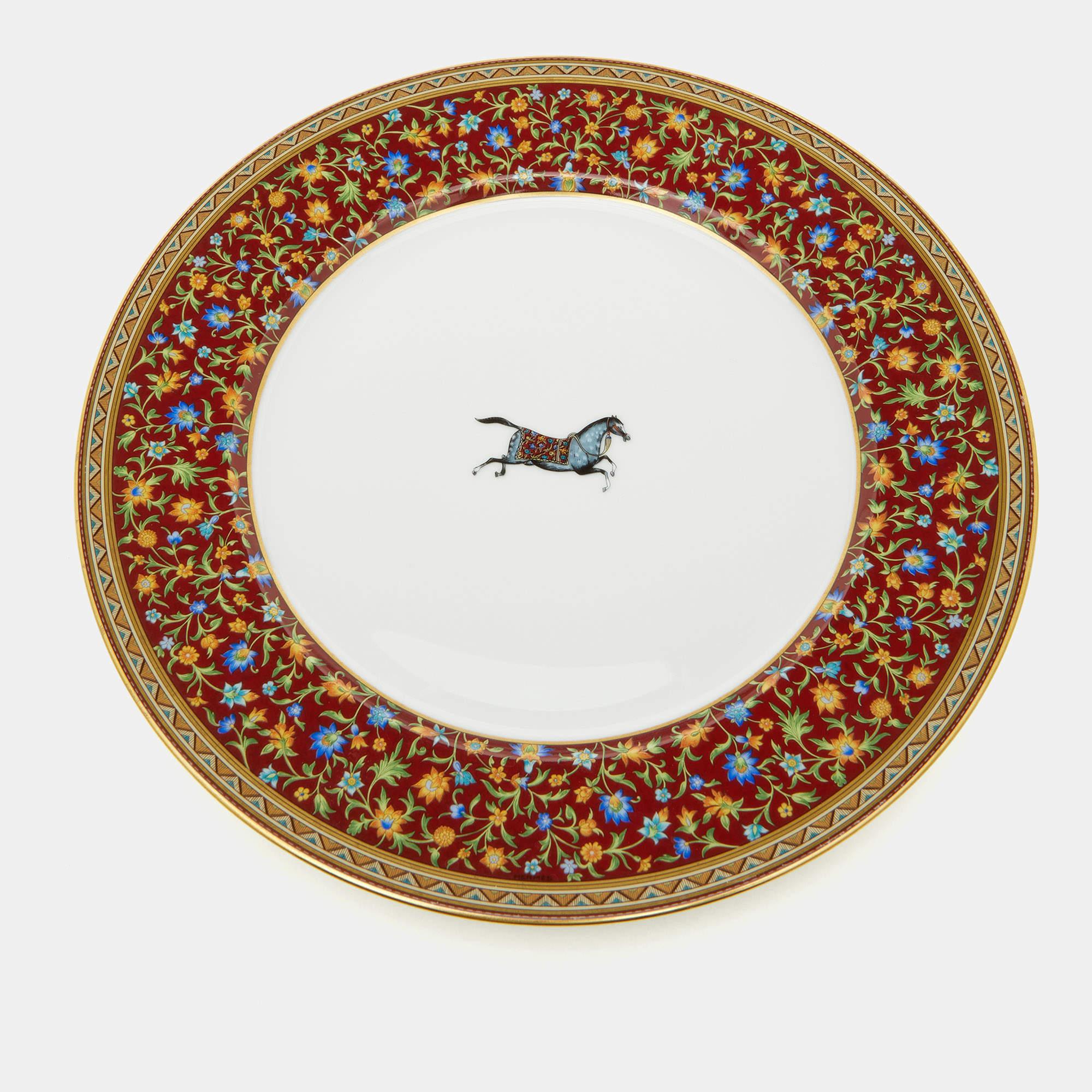 The Hermès dinner plate set exudes timeless elegance. Crafted with fine porcelain, each plate features a delicate rim adorned with a graceful Cheval d'Orient motif in white. Elevate dining experiences with this luxurious and artistic
