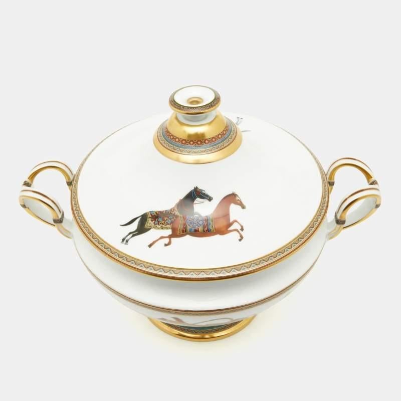 The Hermès soup tureen is an exquisite porcelain piece of functional art. Adorned with intricate hand-painted designs inspired by oriental motifs, the tureen features a graceful rim and elegant handles. Its pristine white surface beautifully