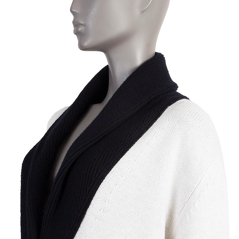Hermes shawl-collar cardigan in off-white and black cashmere (64%) and cotton (36%). With two pockets on the front and ribbed details. Closes with flat buttons in silver-tone metal. Has been worn and is in excellent condition. 

Tag Size 34
Size