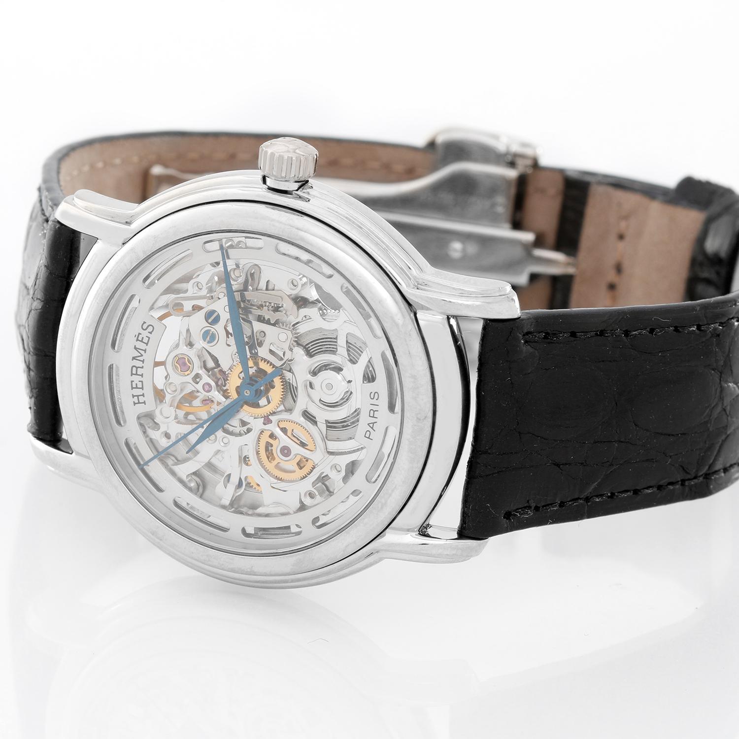 Hermes Sesame Skeleton 18K White Gold Watch  - Automatic winding . 18K White Gold ( 36 mm ) . Skeleton dial with blue steeled hands . Black leather strap with Hermes 18K White Gold deployant buckle . Pre-owned with custom box .