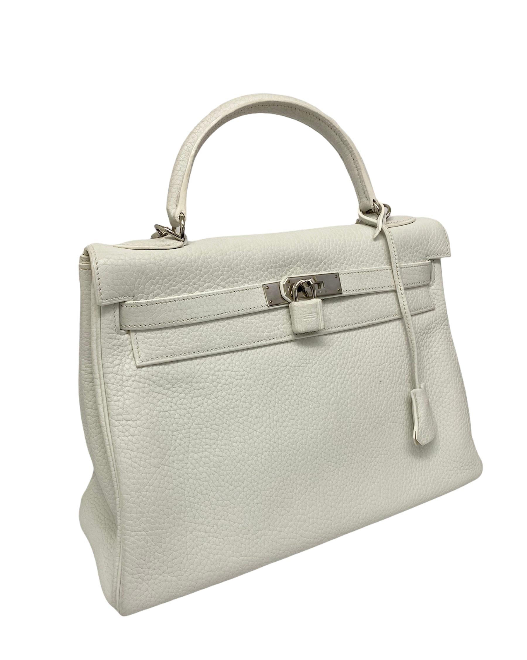 Hermès Kelly 32 model bag made of white togo with silver hardware. Closure with straps and personalized padlock. Equipped with leather handle and removable shoulder strap. Internally quite roomy, lined in leather and equipped with pockets. The bag