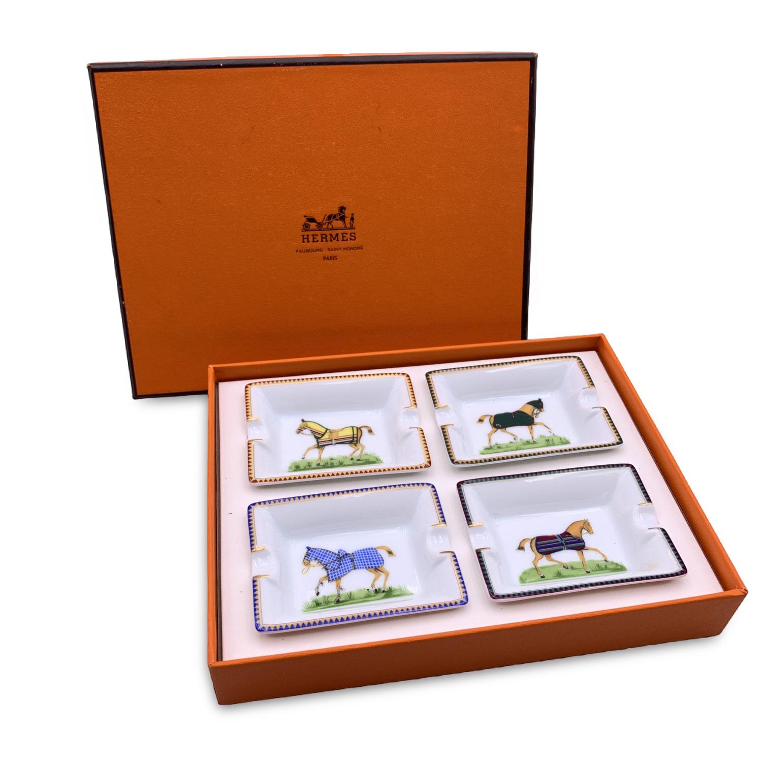 Hermes Vintage set of 4 mini ashtrays Rectangular shape. White porcelain decorated with a print of galloping horses in the centre of them. Each ashtray is marked with 'Hermes Paris' and 'Made in France' writings. Original Hermes orange box included.