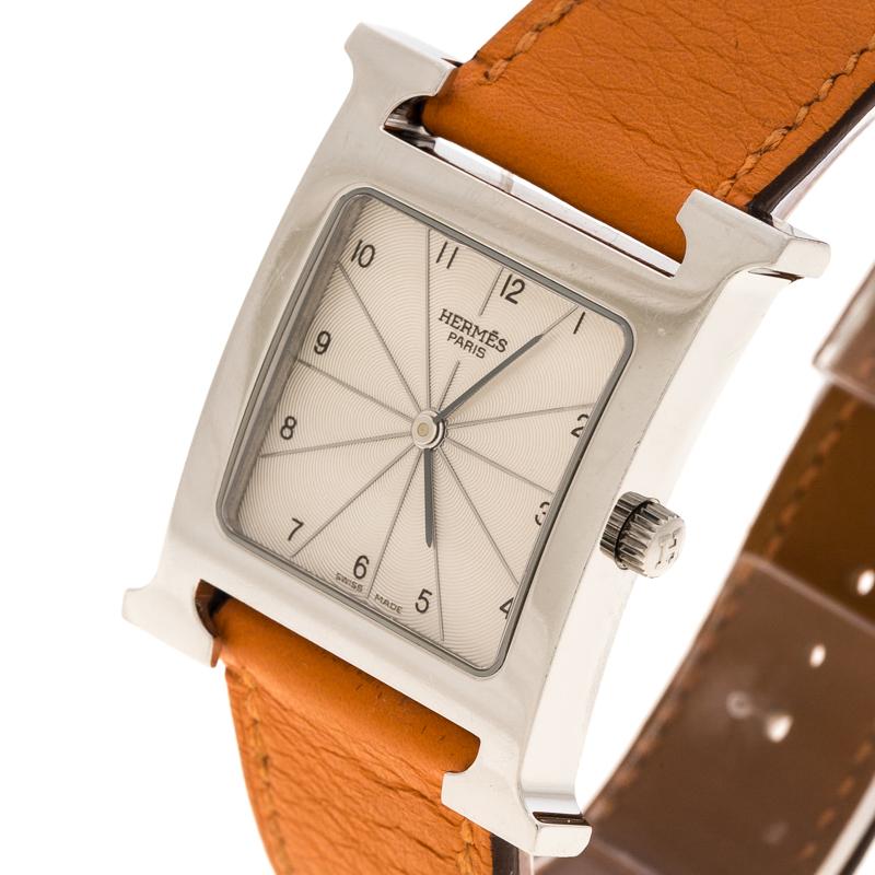 A vision of classic design, this Heure H watch from Hermes exudes quality and sophistication. The watch features the signature 'H' which has been beautifully transformed into a stainless steel case held by an orange leather strap which comes fitted