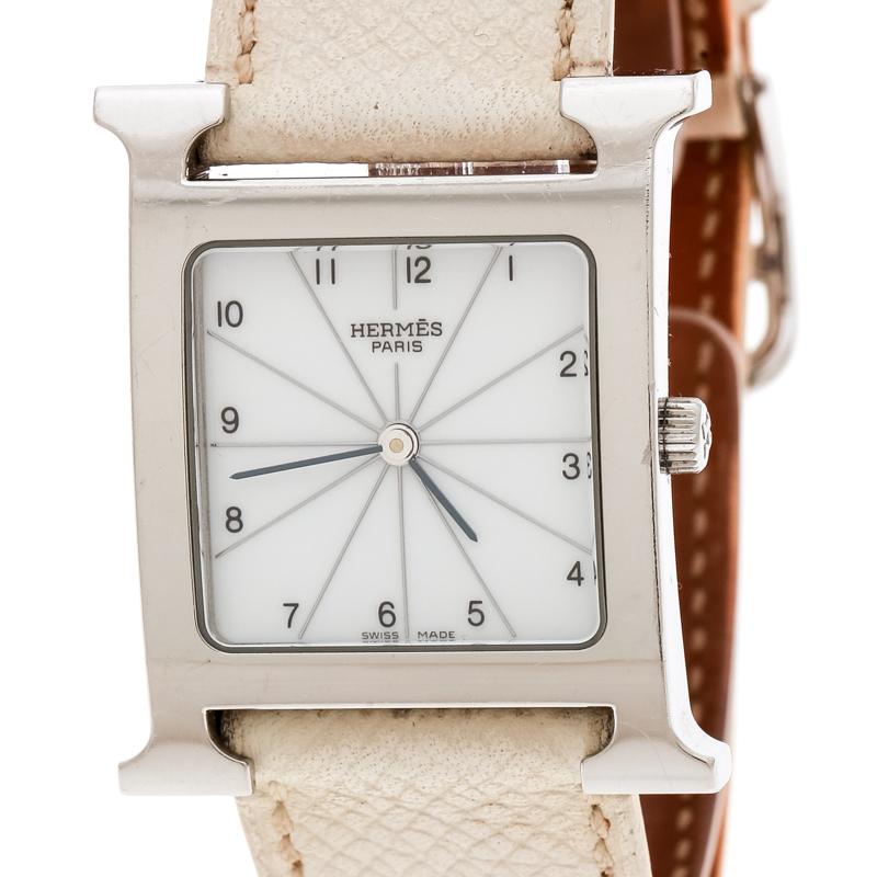 This Heure H watch from Hermes stands for quality and sophistication. The watch features a signature 'H' case in stainless steel and held by cream leather straps with buckle fastenings. Powered by quartz movement, this elegant timepiece has a white