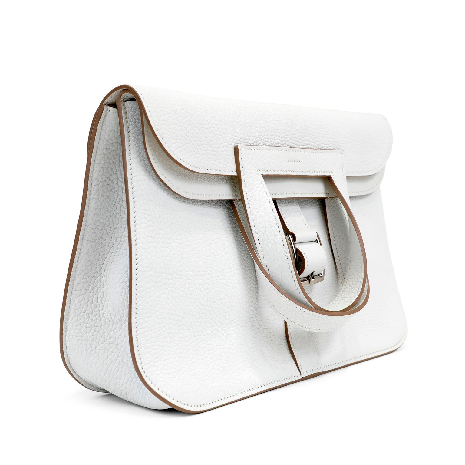 This authentic Hermès White Togo Leather Halzan 31 is in pristine condition.    Hermès bags are considered the ultimate luxury item worldwide.  The Halzan is a lesser known style, but no less chic than the Birkin or Kelly.
Snowy white Togo leather