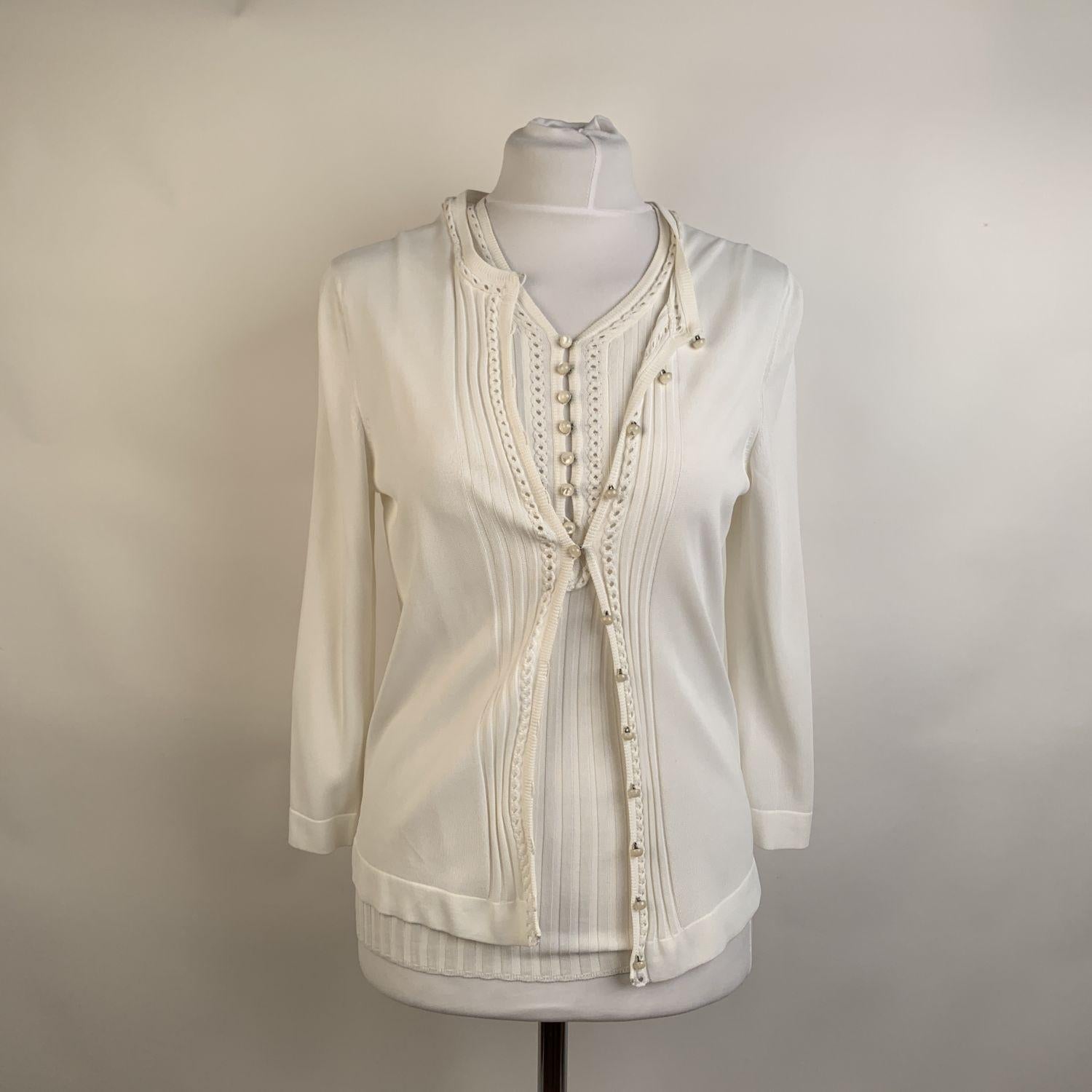 Hermes Twin Set in white color. The cardigan has a front closure with lovely pearl-look buttons. The matching sleeveless top features a button placket on the front, Y neckline and a ribbed hem. Composition: 100% Viscose. Made in Italy. SIZE: 38 FR