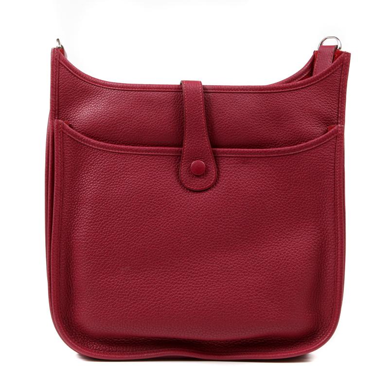 This authentic Hermès Wine Red Clemence Evelyne GM III is in pristine condition. Extremely sought after, the Evelyne is an understated day bag that is stylish and practical.  The third generation sports a rear pocket and adjustable canvas strap.
The