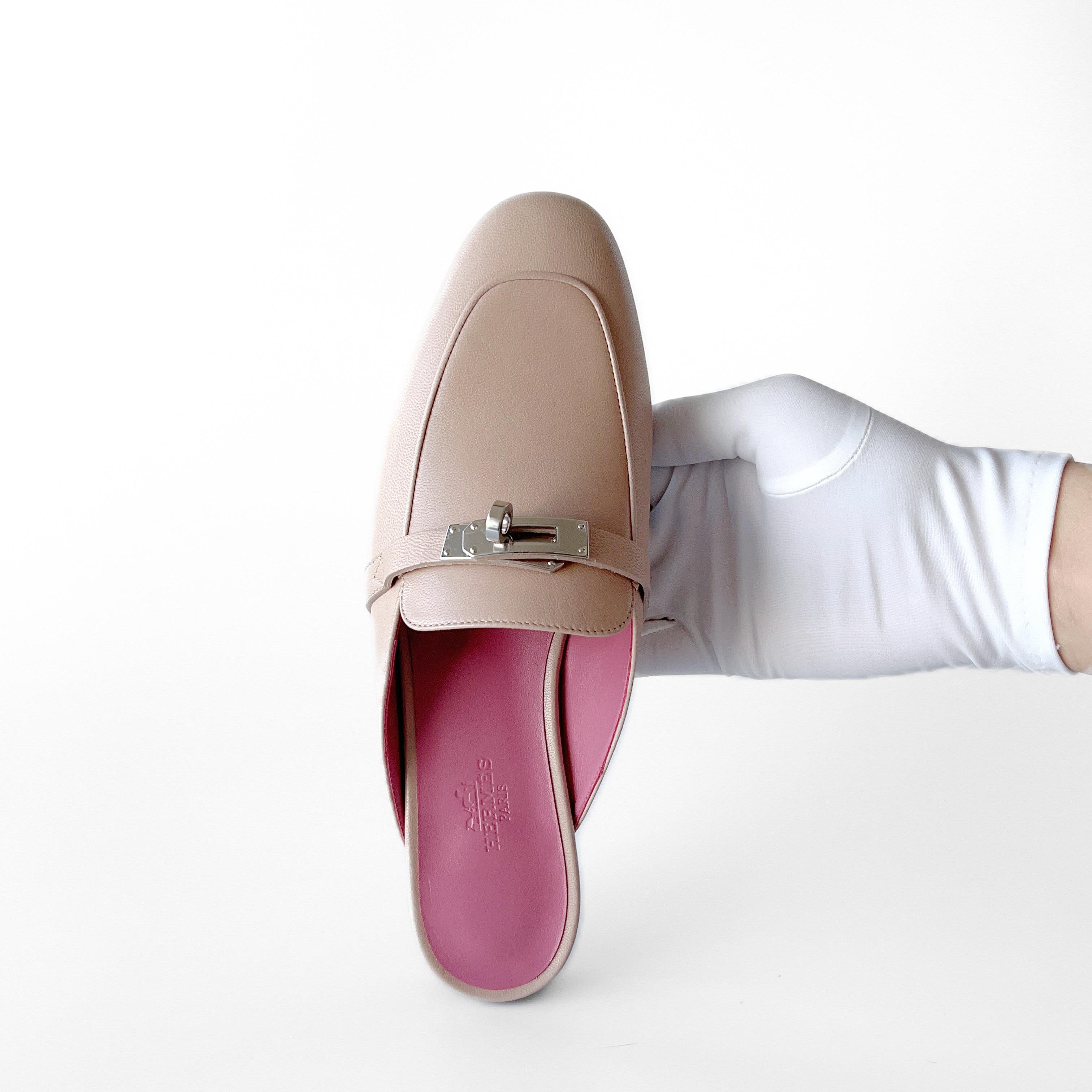 Shop this classic Hermes Mule Slipper in Beige Nude with a Pink In Sole. This pair of Oz Mule slippers has a beautiful Palladium Plated buckle in the classic Kelly style. They are made to be true fitting to size. These are perfect for everyday