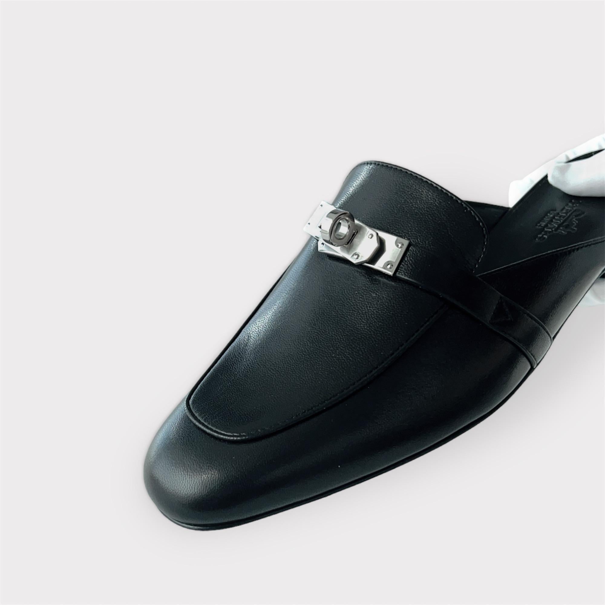 Shop this classic Hermes Mule Slipper in Black with a Palladium plated buckle in the classic Kelly style. These Oz Mule slippers are made out of a soft goatskin leather. They are made to be true fitting to size. These are perfect for everyday