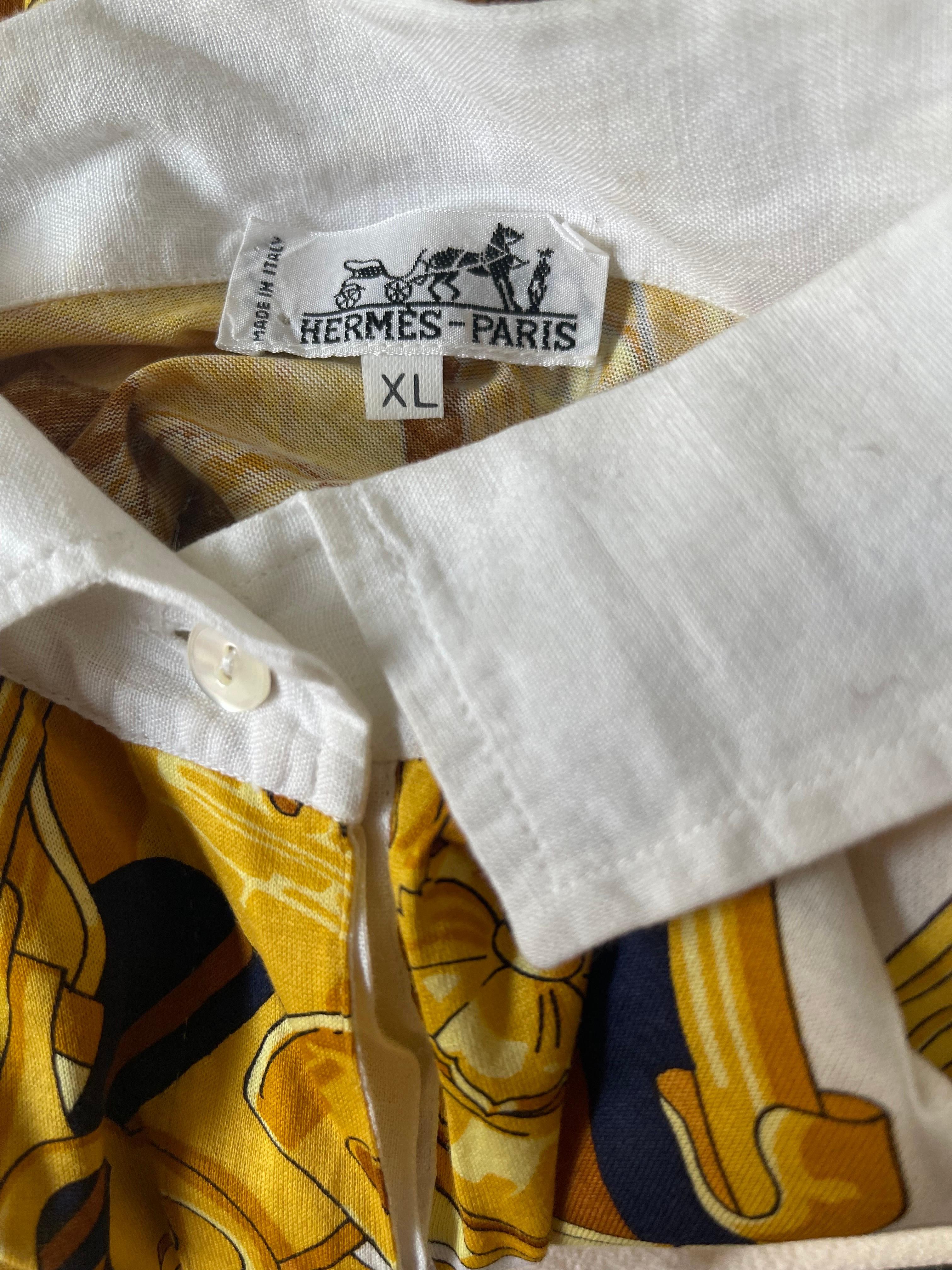 Chic, timeless and classic vintage HERMES ‘ Rythmes ‘ navy blue, gold and white women’s 1990s cotton polo shirt ! White linen collar with hidden buttons. Can easily be dressed up or down. Would look great with white trousers, jeans or shorts. 
In