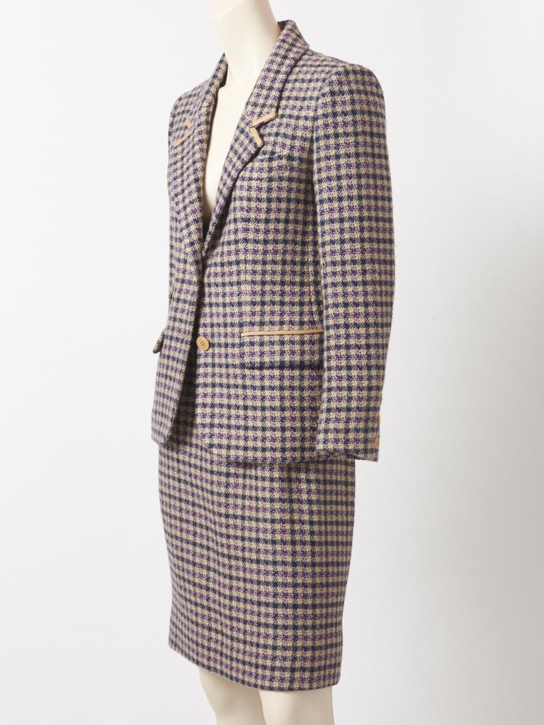 Hermès, navy, beige, with a hint of pink wool tweed skirt suit, having a narrow lapel, flap pockets and beige leather trim at the lapel and pockets. The skirt is slim with a wide waistband , side zipper closure and a back kick pleat. C. late 70's.

