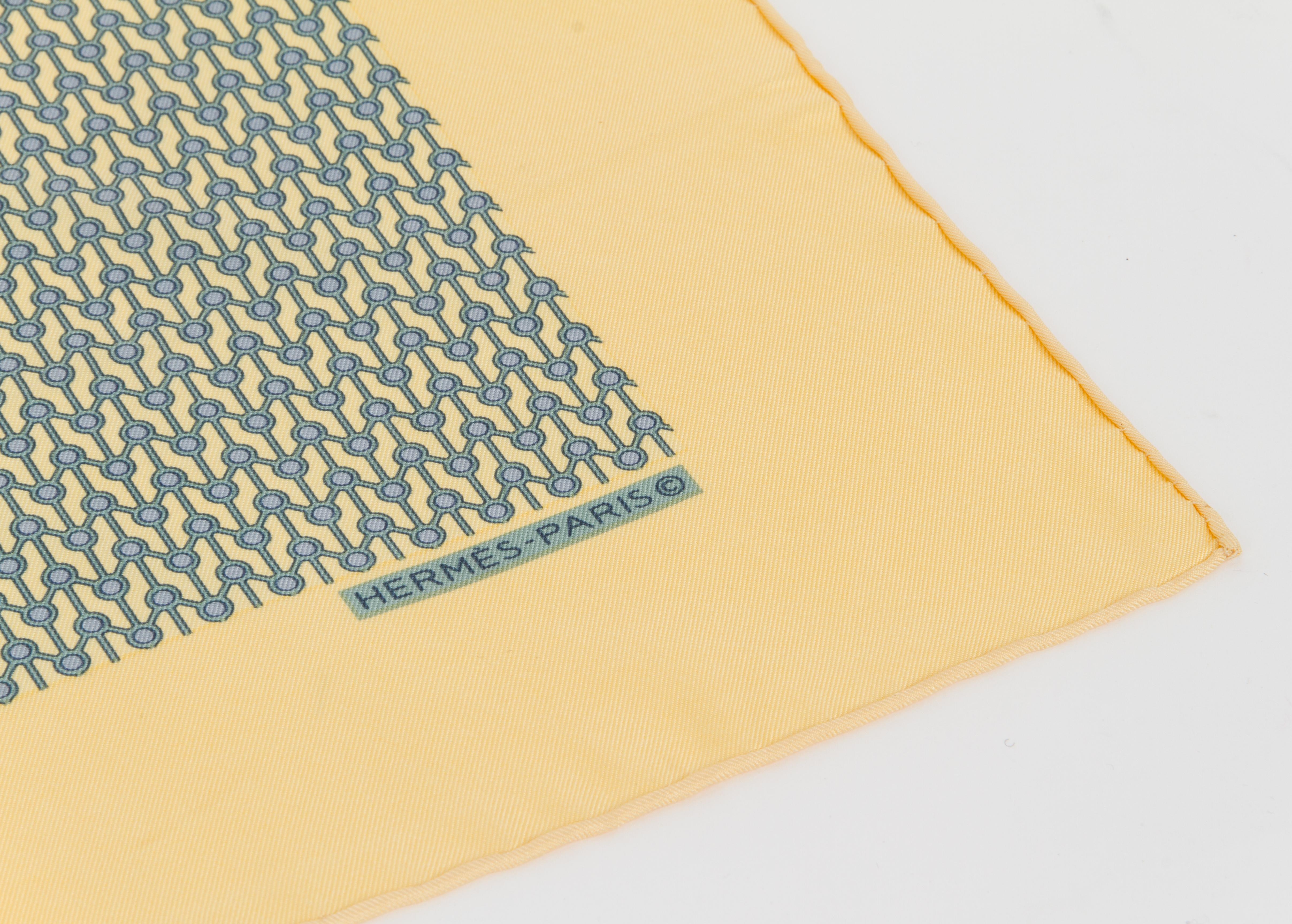 Hermès square silk pocket scarf. Geometric yellow and blue design. Hand-rolled edges.