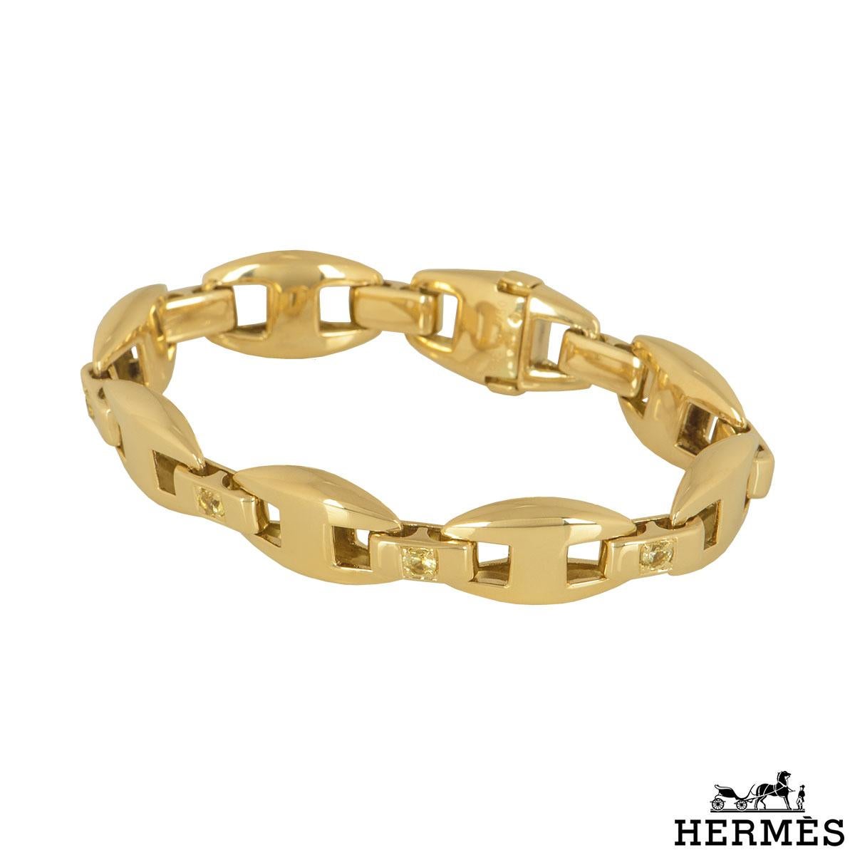 An 18k yellow gold diamond bracelet by Hermes. The bracelet is set with 7 links with a single round brilliant cut diamond on the conjoining bar in between the links. The 8 diamonds have a yellow colour and have an approximate total weight of 1.36