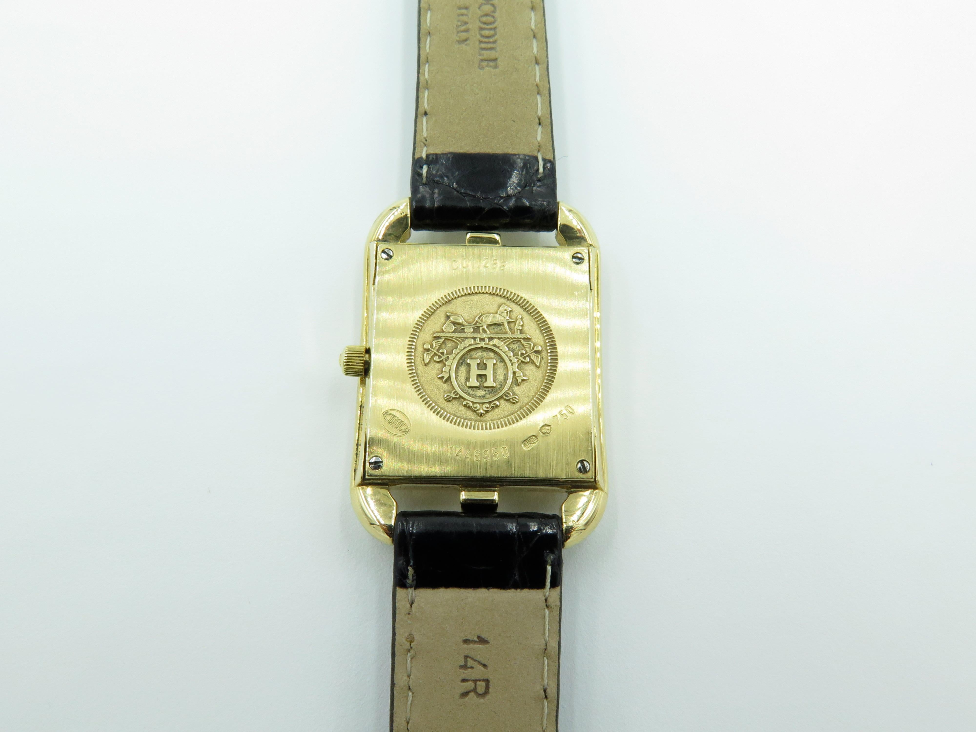An 18 karat yellow gold and diamond Cape Cod watch.  Hermes. 23mm. Of Quartz movement, the white mother of pearl dial with gold tone Arabic numerals, the bezel enhanced by pave set diamonds, joined by a black crocodile band. Thirty (30) diamonds