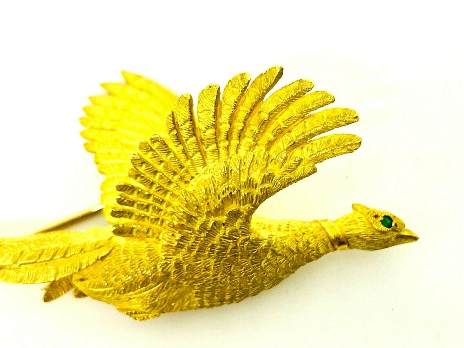 18k yellow gold brooch from Hermes designed as a flying pheasant. Different texture of gold - hammered and polished. The head accented by an emerald eye. Circa 1960s. 
Stamped with Hermes maker's mark, a serial number and French marks. 
Dimensions: