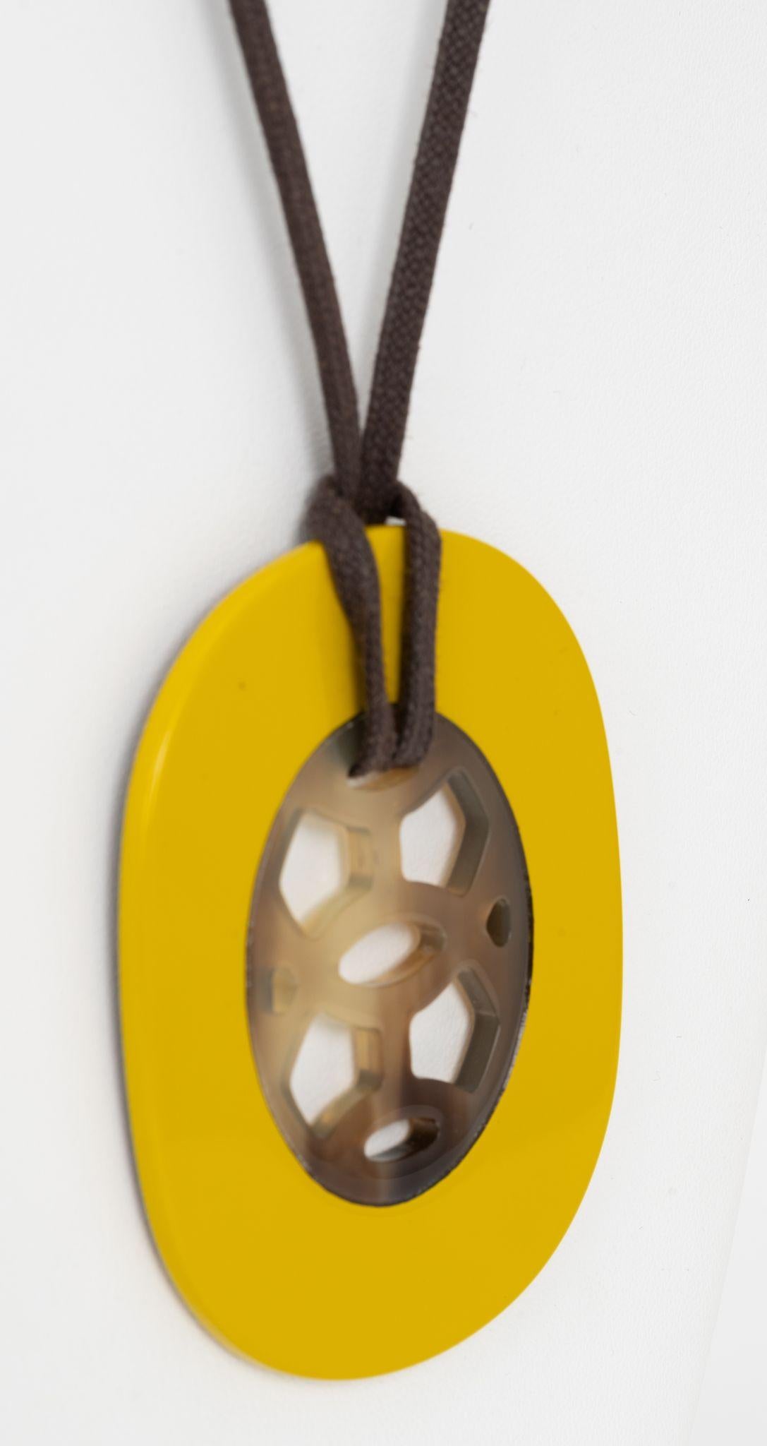 Le pendentif Hermès en corne de buffle est en bois laqué et monté sur un cordon réglable en coton ciré.
Pendentif 2,5