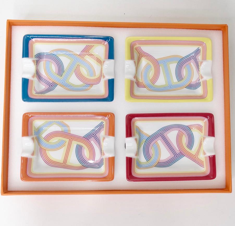 This Hermes set of 4 mini ashtrays is the perfect way to spice up your home decor collection! Four mini porcelain ash trays are decorated using chromolithography to create these vibrant and eye catching ash trays. Featuring a velvet goatskin bases