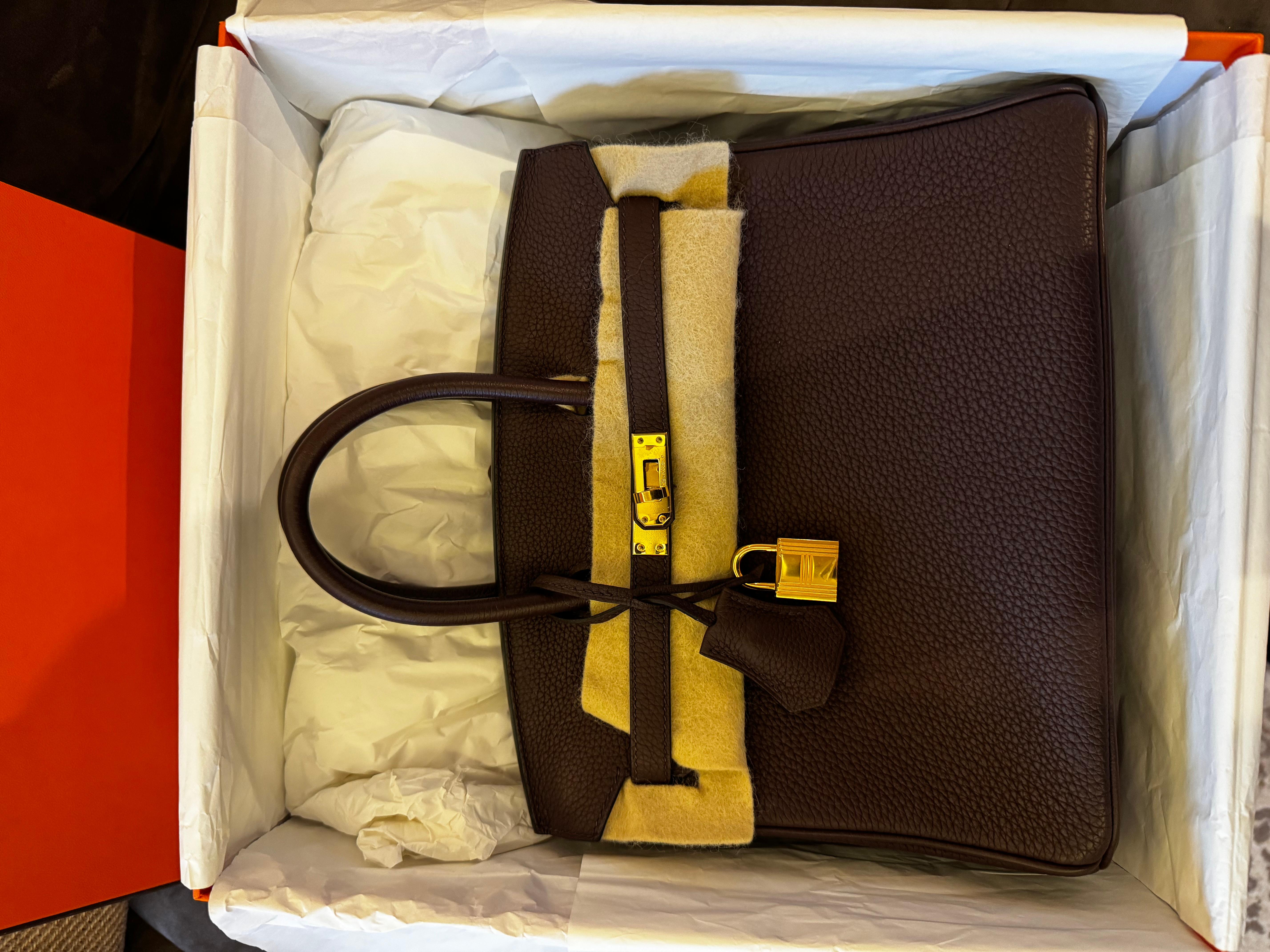 Borsa Hermes birkin 25 di colore rouge H. (un colore bordeaux) con finiture dorate. Francobollo Z anno 2021. Adesivi sulla ferramenta. Viene fornito con scatola, nastro, dustbag, protezione in feltro, clochette, lucchetto e chiavi. 

