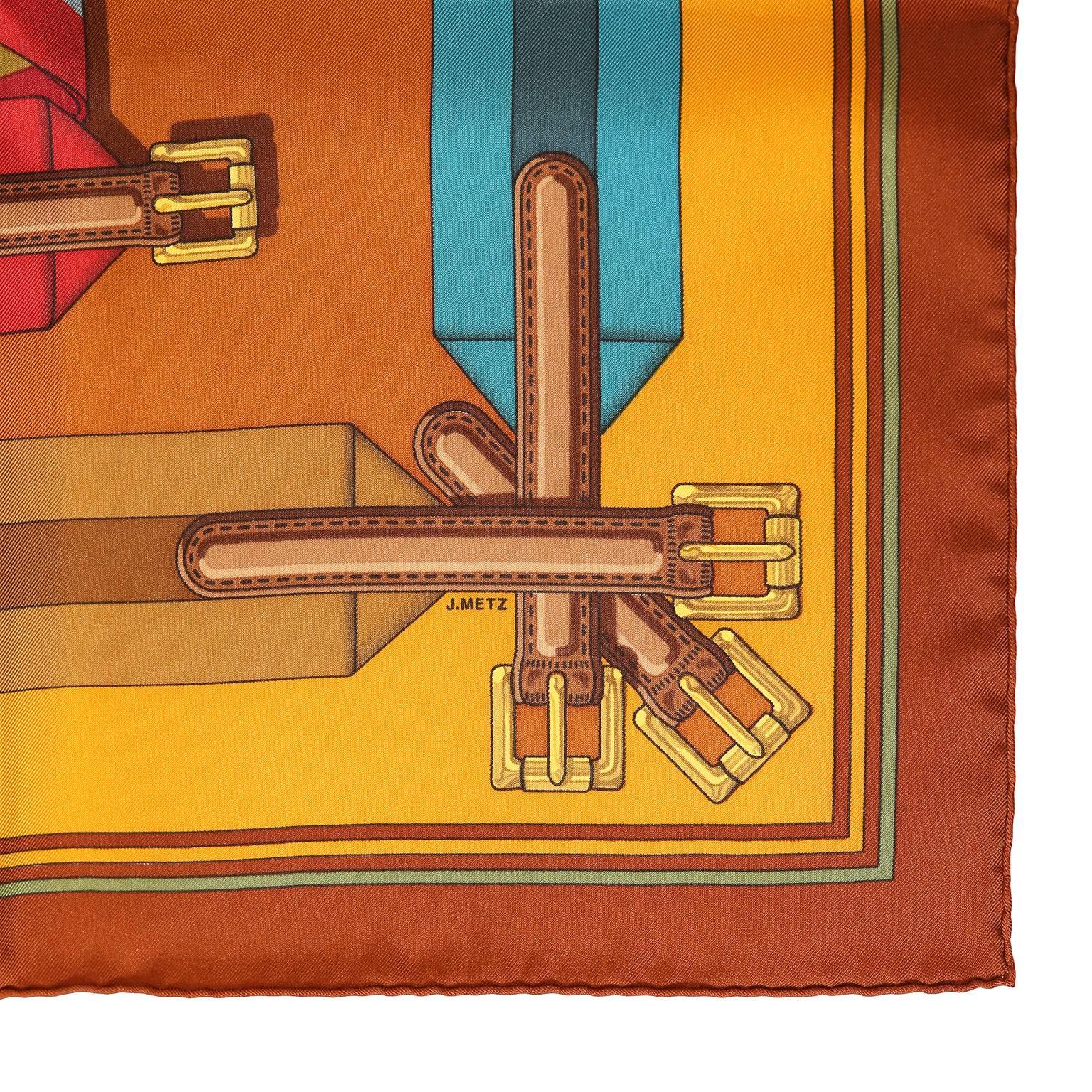 Hermès Belt Print 90 cm Silk Scarf - Pristine Condition 
 The vintage design was originated by J. Metz.  Orange background with three rows of brightly striped ribbon belts hanging decoratively from the bars.   100% silk. Made in France.
A364